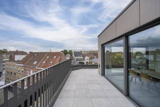 Ontdek dit lichtrijke dakappartement in de Kleine Sint-Jansstraat, midden in het autoluwe winkel-wandelgebied van Kortrijk. Een unieke kans om te wonen op een rustige plek, terwijl u letterlijk omringd bent door alles wat de binnenstad zo aantrekkelijk maakt: het Shopping Center K, de Veemarkt, gezellige boetieks en fijne horeca.Met zijn 100 m² bewoonbare oppervlakte en een riant terras van maar liefst 33 m² biedt dit appartement een uitzonderlijk gevoel van ruimte. Vanuit het terras geniet u van een aangenaam, open zicht over de stad — ideaal om te ontspannen in alle privacy.Daarbovenop kan dit appartement aangekocht worden aan het verlaagde btw-tarief van 6%, wat het geheel nog aantrekkelijker maakt.Kleinschalige residentieTopligging in het autoluwe winkel-wandelgebied van KortrijkOp wandelafstand van Shopping Center K, de Veemarkt en tal van winkels &amp; horeca100 m² bewoonbare oppervlakte met een uitstekende indelingZeer ruim terras van 33 m² met open zicht over de stadTwee slaapkamersRustige ligging, ondanks de centrale positie in hartje KortrijkLichtrijke leefruimte door de hoge positie en grote raampartijenMogelijkheid tot aankoop aan 6% btwIdeaal voor wie comfortabel en stads woont, of zoekt naar een slimme investering