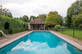 <p><span>Dit uniek eigendom bevindt zich in een rustige &amp; kindvriendelijke omgeving hartje Edegem. De villa ligt op een uitzonderlijk perceel van 3.300m² en wordt omringd door een betoverende parktuin met zwembad en een polyvalent gebouw. De woning werd pas begin jaren 2000 ontworpen.  Kosten noch moeite werden gespaard om als resultaat een  hoogwaardig interieurdesign. samenspel van comfort, veiligheid en pure verfijning te hebben gerealiseerd. Elke ruimte is conceptueel doordacht en straalt een serene, inspirerende en luxueuze woonbeleving uit. De smaakvol ingerichte leefruimtes creëren een warme en uitnodigende sfeer, waar esthetiek en functionaliteit elkaar naadloos aanvullen. Met circa 600 m² woonopp. biedt deze villa ongeëvenaarde ruimte en veelzijdigheid. Binnenin geniet je van een zee van ruimte en licht. Beneden treffen we een aparte otvangstruimte met biblotheekkasten. De leef-en eetruimte geven uit op het terras en hebben een schitterend zicht op de tuin. Eveneens als de leef-en eetkeuken met doorgang naar de 3 inpandige garages. Boven bevinden zicjh maar liefst 7 slkm en 3 bdkm. De kelderruimte van ca 250m² is eveneens fenomenaal. Dit is een absolute buitenkans voor mensen die op zoek zijn naar een stijlvolle, luxueuze villa die meteen instapklaar is. Dit vastgoed biedt enorme mogelijkheden en verkeert in perfecte staat. </span></p><p><span> </span></p><p><span>Extra's:</span></p><p><span> </span></p><p><span>In de tuin is er ook een conciërgewoning (woonkamer, kitchenette, douche en slaapkamer). </span></p><p><span>Prachtig poolhouse met bbq en een schitterend "GP Construct" zwembad. (12.5 *5m)</span></p><p><span>Fantastische en voortreffelijke tuin. </span></p><p><span>Indrukwekkende entree van het pand aan de zijkant via een lange privélaan</span><span>. </span></p><p><span>Volledig verwarmde kelderverdieping.</span></p><p><span>Aanwezigheid van een zolder.</span></p><p><span> </span></p><p><span> </span></p>