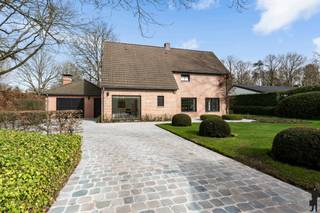<strong>Instapklare, stijlvol gerenoveerde villa in residentiële wijk op de grens met Schilde, op een prachtig perceel van ca. 2.300 m²!</strong><br /><br /><strong>Deze prachtige villa bevindt zich in de rustige en residentiële wijk Den Drijhoek, op de grens van Zoersel en Schilde. De woning werd recent grondig vernieuwd en combineert een hoogwaardige afwerking met een aangename lichtinval en een doordachte indeling. Dankzij de grote raampartijen, mooie materialen zoals travertin en eiken parket, en het zicht op de verzorgde tuin, ontstaat een bijzonder warme en luxueuze woonbeleving.</strong><br /><br /><strong>De gelijkvloerse verdieping:</strong><br />- een stijlvolle inkomhal op beige travertin met gastentoilet en handenwasser,<br />- een vernieuwd bureau op houten parketvloer met ingemaakte bureaumeubel, veel lichtinval dankzij een raam tot op de grond en een elegante stalen deur,<br />- een sfeervolle woonkamer met visgraat eiken parketvloer, een ingemaakte gashaard met Italiaanse natuursteen en maatwerk tv-meubel, grote raampartijen tot op de grond met prachtig zicht op de tuin,<br />- een eetkamer in erker met dezelfde parketvloer en een directe toegang tot het terras en de tuin,<br />- een volledig uitgeruste keuken op beige travertin met dubbele spoelbak, natuurstenen eiland en kwalitatieve inbouwtoestellen (Miele inductiekookplaat en dampkap, Siemens vaatwasser, Siemens combi-oven en heteluchtoven, Miele koelkast en vriezer High Line),<br />- een praktische achterliggende wasplaats met ingemaakte kasten, aansluiting voor wasapparatuur en warmtepompboiler,<br />- een tweede leefruimte / tv-kamer / bureau met travertinvloer, open haard op hout, grote raampartijen tot op de grond en toegang tot terras en tuin,<br />- een berging met spoelbak, cv-ketel (Junkers) en een tweede ingang of personeelsingang.<br /><br /><strong>De eerste verdieping:</strong><br />- een nachthal met apart nachttoilet (hangtoilet Villeroy &amp; Boch) en ingemaakte kast,<br />- een ruime hoofdslaapkamer met ingemaakte kasten,<br />- een hoofdbadkamer met dubbele lavabo (Villeroy &amp; Boch), inloop-regendouche en ingemaakte kasten.<br />- een tweede slaapkamer op parket met ingemaakte kast,<br />- een derde slaapkamer op parket met ingemaakte kasten,<br />- een vierde slaapkamer op parket met ingemaakt bed en kast,<br />- een douchekamer met lavabo (Villeroy &amp; Boch), en inloop-regendouche,<br /><br /><strong>De zolder:</strong><br />- een ruime zolderverdieping onder het dak bereikbaar via een vlizotrap,<br />- het dak werd volledig langs de binnenzijde geïsoleerd (2025).<br /><br /><strong>De tuin:</strong><br />- een prachtige, volledig omheinde (automatische poort) en uitstekend onderhouden tuin,<br />- meerdere aangename terrassen met buitenverlichting,<br />- een ruim tuinhuis,<br />- een drainagesysteem voorzien over het volledige perceel.<br /><br /><strong>Algemeen</strong>:<br />- uitstekende ligging in postcode Zoersel, op de grens met Schilde,<br />- rustige en residentiële omgeving,<br />- zeer lichtrijke woning dankzij grote raampartijen,<br />- gelijkvloerse verdieping, badkamers en bureau recent volledig vernieuwd,<br />- alarmsysteem aanwezig,<br />- kwalitatieve en duurzame materialen doorheen de hele woning.<br /><br /><strong>Een bijzonder verzorgde en instapklare villa op een gegeerde locatie, waar ruimte, comfort en stijlvolle afwerking perfect samenkomen. Ideaal voor wie op zoek is naar een kwalitatieve gezinswoning in een rustige, residentiële omgeving.</strong>