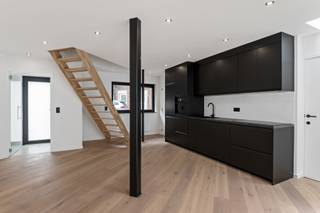 <p>In the Sleutelstraat, one of Kontich’s most charming streets with its historic façades and tranquil setting, lies a fully renovated home where authenticity meets modern comfort. With its favorable EPC A label, you’ll benefit from low energy costs and a sustainable living experience.</p>
<p>Behind the entrance hall, a bright living area unfolds, where large windows and a thoughtful layout create an open and inviting atmosphere. The sleek black kitchen is a true eye-catcher and blends seamlessly with the living space. From here, you step directly into the city garden — a private spot to relax in peace, while still being just steps away from the vibrant town center. Upstairs, the sense of space and light continues with two elegant bedrooms and a refined bathroom featuring a walk-in shower.</p>
<p>This property is perfect for those who appreciate character, natural light, and contemporary comfort — all in a central yet quiet location in Kontich.</p>
<p><strong>Technical details:</strong> Fully insulated, high-efficiency double glazing in PVC or aluminum, central heating on gas, and solar panels. Laundry connections in the bathroom, two storage rooms, and a fully equipped kitchen. Urban planning information and soil certificate available. Not located in a flood risk zone (P- and G-score C). No renovation obligation. Asbestos-safe.</p>