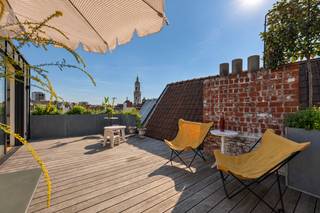 Prachtige duplex - penthouse met loft vibes en een zee van licht, hoge raampartijen/plafonds. <br /><br />Op de eerste verdieping vindt u de master slaapkamer, voorzien van ingemaakte kasten en rustig gelegen aan de achterkant. Verder een ruime badkamer met inloopdouche, toilet en dubbele wastafel. Voorts een volwaardige tweede slaapkamer en een aparte wasplaats met dressingruimte. <br /><br />Op de tweede verdieping wordt u verrast door een fantastische open ruimte. Zonlicht schijnt binnen via zowel de voor als achterkant en hoge raampartijen / plafonds zorgen voor een unieke sfeer. De living/woonkamer loopt vloeiend over naar een open keuken met kookeiland. <br /><br />Verder op de derde verdieping een zalig zonneterras met panoramisch zicht over de historische stad, maximale privacy en rust. <br /><br />Instapklaar, rustig gelegen pareltje voor wie op zoek is naar licht, ruimte, loftgevoel en XL buitenruimte. <br /><br />Mogelijkheid om een parking te huren om de hoek.