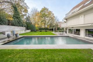 Exclusief te koop: Deze elegante villa ligt verscholen in een rustig en discreet paadje in het hart van Het Zoute, op een mooi terrein van 1.298...