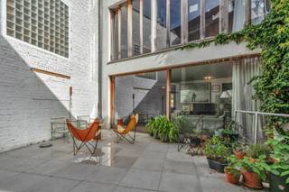 <p><span>In het hart van de Dansaertwijk ligt dit herenhuis uit 1860, volledig gerenoveerd in 2017, met 384 m² bewoonbare oppervlakte. Achter de bewaarde historische gevel schuilt een hedendaagse gezinswoning. Het gelijkvloers biedt een inkomhal, een bureau met eigen toegang – ideaal voor een vrij beroep –, een polyvalente ruimte van 30 m² en een garage voor 2 wagens (tandem) met laadpaal. Op de eerste verdieping: een open keuken met eiland en professionele uitrusting, een royale eetkamer en een lichtrijke leefruimte met open haard, verlengd door een zuidgericht terras van 41 m². Op de tweede verdieping: drie slaapkamers, een badkamer met bad en dubbele wastafel en een apart toilet. Op de derde verdieping: een ouderlijke suite met dressing op maat en badkamer met inloopdouche, een vijfde slaapkamer en een wasruimte. Eiken parket op alle verdiepingen en kelder van 45 m². 100% elektrisch: warmtepomp met vloerverwarming, 24 zonnepanelen met thuisbatterij en ventilatie met warmterecuperatie. EPC: C+. Elektriciteit conform. Op wandelafstand van Sint-Katelijne, de Beurs en het kanaal. Een zeldzaam adres waar geschiedenis en comfort samenkomen. Zeker te bezoeken.</span></p>