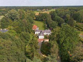 <span>Gelegen in een residentiële laan tussen het centrum van Schilde en ś-Gravenwezel bevindt zich deze exclusieve Vlassak-Verhulst villa op een perceel van 7.637 m2. De ruime Villa beschikt onder meer over een verwarmd binnenzwembad en een volledig afgescheiden appartement dat perfect als kangoeroewoning kan fungeren. De mooi aangelegde tuin is zuidwest gelegen en geniet van een eindeloos zicht op de weilanden. Het perceel is praktisch geheel omheind en dankzij de aangelegde tuinpaden en verlichting wordt er een gevoel van rust en privacy gecreëerd. De inkomhal met klassieke trap, gastentoilet en toegang naar de kelder, annex wijnkelder vind men centraal terug in de woning. Van hieruit bereikt men een woonkamer met statige open haard. Deze kamer is momenteel als biljartruimte en bureau in gebruik. Aan de andere zijde van de woning bevindt zich de TV/zitruimte met prachtig zicht op de tuin. Aansluitend komen we terecht in de open leefruimte. We treffen hier een volledig met luxueuze materialen uitgeruste keuken, een grote eetkamer en een gezellige zitruimte met sfeervolle BARBAS cassette haard en schuifpui naar een prachtig overdekt terras met grote open haard. Verder vinden we beneden nog een wasruimte met berging en een inpandige automatische garage voor twee wagens en ruime parking buiten. Op de eerste verdieping treffen we na de hal eerst en vooral het master bedroom-gedeelte aan. Via een dressing met ingemaakte kasten komen we terecht in het slaapgedeelte en de luxueuze badkamer met o.a. massage-douches. Bovendien is er nog een aparte inloopdressing. Verder beschikt de eerste verdieping over een aparte leefruimte met open keuken/leefruimte, een zeer ruime slaapkamer en een badkamer. Boven één van de slaapkamers is er een toegang naar de zolder waar zich de Viessmann gasverwarming bevindt. Het bijgebouw uit 2010 bestaat uit een volledig geautomatiseerd onderloop zwembad prachtig afgewerkt met mozaiek. Deze ruimte geniet van een schitterend uitzicht over de tuin en de aanpalende weilanden. Verder vinden we in het bijgebouw nog een sauna en een infrarood sauna en een volwaardige badkamer. De giga kelder van het bijgebouw werd enerzijds ingedeeld als technische ruimte voor het zwembad en anderzijds als werkplaats en bergruimte.</span>