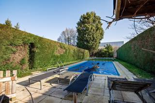 Deze woning ligt op een toplocatie in het centrum van Koningshooikt.<br /><br />Momenteel heeft deze woning vooraan een winkelruimte maar eventueel enkel wonen is perfect mogelijk.<br /><br />De woning bestaat uit een lichtrijke leefruimte, open keuken en eetkamer. De keuken is volledig geïnstalleerd en oogt landelijk modern.<br />De winkelruimte, welke zich vooraan situeert, beschikt over een werkruimte/atelier alsook de garage, wasplaats en doorgang naar de tuin.<br /><br />Verder is er op het gelijkvloers nog een berging, wasplaats en apart toilet aanwezig.<br /><br />Op de eerst verdieping bevinden zich 3 ruime slaapkamers (18,5m²/18,5m²/11m²) en een badkamer. De badkamer is uitgerust met een ligbad, douche, toilet en een dubbele lavabo in een praktisch badkamermeubel. <br /><br />Tot slot is er de aangename tuin met terras en zwembad.<br />Deze buitenruimte is de ideale plek om tijdens de zomermaanden tot rust te komen en te genieten van het buitenleven.<br /><br />Troeven:<br />+ Ligging op toplocatie<br />+ EPC label C<br />+ 3 Ruime slaapkamers<br />+ Tuin<br />+ Zwembad<br />+ Garage<br /><br />Interesse in deze centraal gelegen woning? Neem gerust contact op voor een bezoek ter plaatse via 03 337 50 70 of info@vbvastgoed.be.