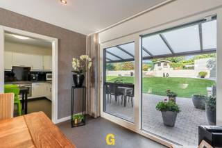 Langs de Anjelierenlaan ter hoogte van nummer 6 ligt deze netjes en geslaagd gerenoveerde halfopen woning, op een mooi gelegen perceel van 6a 06ca.<br /><br />De woning ligt als laatste in de rij in de Anjelierenlaan, een rustige doodlopende weg die uitgeeft op landbouwgebied. Hier is het bijzonder aangenaam wonen in een gemoedelijke, rustige buurt omgeven door groen. Het centrum van Hoeselt ligt op slechts een tiental minuutjes met de fiets of te voet. In de nabije omgeving vindt men supermarkten, scholen, dokters, bakkers en andere dagelijkse voorzieningen. Het centrum van Bilzen ligt op een viertal kilometer. De oprit van de E313 bereikt men na amper anderhalve kilometer.<br /><br />De woning – nog steeds bewoond door de eerste eigenaar – is instapklaar en verkeert in een zeer nette staat, dankzij voortdurend uitstekend onderhoud en regelmatige renovatiewerken. <br /><br />Met het oog op een gunstig EPC en een betere energiezuinigheid werden de ramen en CV-installatie vervangen, het dak geïsoleerd en zonnepanelen geplaatst. Zo kan op heden een EPC worden voorgelegd met een score van 217 kWh/m² p.j. – label C.<br /><br />Voor het oog en beter wooncomfort werden keuken en badkamer al eens vernieuwd en werd een nieuwe vloer gelegd in steentapijt, uniform en knap doorgetrokken in de hal, leefruimte en keuken. <br /><br /><br />De koper zal hier een instapklare woning aantreffen, klaar er een fijne nieuwe thuis van te maken, zonder dat men zich hier zorgen moet maken over onverwachte aankomende kosten.<br /><br />INDELING / OMSCHRIJVING<br /><br />GELIJKVLOERS<br />-Inkomhal met toilet, knap op maat gemaakte trap en vernieuwde vloer - al bij het binnenkomen krijgt men hier meteen een frisse, verzorgde indruk die men ook verder in de woning zal kunnen terugvinden<br />-Lichtrijke woonkamer met ramen voor- en achteraan en zicht op terras en tuin<br />-Verzorgde, degelijk ingerichte keuken met zicht op de tuin<br />-Handige bergruimte<br />-Ruime inpandige garage<br />VERDIEPING<br />-Traphal<br />-Twee ruime slaapkamers<br />-Derde, kleinere slaapkamer<br />-Netjes verzorgde badkamer met douche, badkamermeubel en toilet<br />-Zolderluik naar de zolder, bruikbaar als extra stockage<br />BUITENOMGEVING<br />-Breed perceel aan de straatzijde met voldoende parkeermogelijkheden<br />-Overdekt terras<br />-Verzorgd gazon, volledig omheind, kindvriendelijk en met veel privacy<br />-Tuinberging met hoger gelegen zithoek, met mooi zicht op de omgeving<br /><br />ENKELE GUNSTIGE (TECHNISCHE) KENMERKEN<br />-EPC: 217 kWh/m² p.j. – label C<br />-Aluminium ramen met HR-glas<br />-CV-ketel op aardgas – ATAG<br />-Zonnepanelen – 3.600 Wp<br />-Spouwmuren mogelijk verder na te isoleren<br />-Airco in de leefruimte en centraal in de hal op de verdieping<br />-Geen renovatieplicht<br />-Geen opname in het maatregelenregister<br />-Rolluiken boven en onder, deels manueel en deels elektrisch bedienbaar<br />-P-score A – G-score A<br />-Recent aangelegde regenwaterput met aansluiting op toilet en wasmachine (± 2017)<br /><br />Deze nette, frisse halfopen woning kan een interessant aanbod zijn voor gezinnen die op zoek zijn naar een piekfijn verzorgde en instapklare (starters)woning, die al heel wat belangrijke renovatiewerken heeft mogen ondergaan, telkens degelijk en vakkundig uitgevoerd. De ruime, kindvriendelijke tuin en rustige ligging grenzend aan het groen maken het hier aangenaam wonen, met tegelijkertijd een vlotte toegang tot alle faciliteiten die een bloeiende gemeente zoals Hoeselt te bieden heeft.