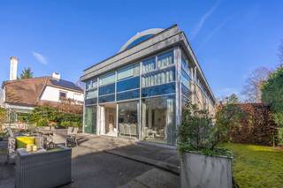 <p><strong>Riante en moderne villa in de gegeerde Elsdonckwijk – Wilrijk</strong></p>
<p>Deze prachtige villa combineert ruimte, comfort en luxe in een van de meest prestigieuze villawijken van Wilrijk. Gelegen in een rustige straat, op korte afstand van openbaar vervoer, supermarkten, restaurants en belangrijke in- en uitvalswegen, geniet u hier van optimale bereikbaarheid én privacy.</p>
<p><strong>INDELING</strong></p>
<p><strong>Gelijkvloerse verdieping:</strong><br />De ruime inkomhal verwelkomt u en leidt naar de lichtrijke living met eetruimte en zitruimte. De volledig ingerichte keuken is verbonden met de eetkamer via een brede schuifdeur, wat een open, vloeiende indeling creëert en tegelijk de mogelijkheid biedt tot afzonderlijke ruimtes. De keuken is uitgerust met een 5-pits gasvuur, hete luchtoven, afwasmachine en grote Amerikaanse koelkast en loopt naadloos over in de praktische bijkeuken met ingemaakte kasten. Zowel de keuken als de living genieten van grote raampartijen met toegang tot het terras en de zonnige tuin.<br /><br />Onder het terras bevindt zich een voormalig zwembad dat opnieuw in gebruik kan worden genomen – een unieke troef voor wie droomt van een eigen zwembad.</p>
<p>Daarnaast is er een volledig ingerichte suite met slaapkamer, badkamer met bad, douche, dubbele wastafel, wc en dressingruimte. Deze is ideaal te gebruiken als gastenverblijf of thuiskantoor, wat extra flexibiliteit biedt voor gezinnen of thuiswerkers.</p>
<p>De garage biedt plaats aan één wagen en meerdere fietsen.</p>
<p><strong>Eerste verdieping:</strong><br />Via een gepantserde deur bereikt u de nachthal met toegang tot 5 ruime slaapkamers (ca. 14 m², 15 m², 19 m², 17 m² en 23 m²). Slaapkamers 1 en 2 delen een badkamer met dubbele wastafel, bad met douchefunctie en aparte wc. Slaapkamers 3 en 4 beschikken elk over een en suite badkamer met dubbele wastafel en bad met douchefunctie. De masterbedroom (ca. 23 m²) is voorzien van ingemaakte kasten en een en suite badkamer met ligbad, dubbele wastafel, douche en wc en en baadt dankzij de grote raampartij in natuurlijk licht.</p>
<p><strong>Tweede verdieping:</strong><br />De recent gerenoveerde zolderverdieping is omgevormd tot een zelfstandig appartement met nachthal en ingemaakte kasten, badkamer met ruime inloopdouche, dubbele wastafel en toilet, een slaapkamer en een grote polyvalente ruimte van ca. 30 m². <br />Deze ingerichte zolder is bijzonder geschikt indien de woning als kangoeroewoning wordt gebruikt, waardoor wonen met meerdere generaties of een combinatie van privé en werkruimte eenvoudig mogelijk is.</p>
<p><strong>BIJZONDERHEDEN</strong></p>
<ul>
<li>Ruime en moderne villa met hoogwaardige afwerking</li>
<li>Prestigeuze locatie in de Elsdonckwijk</li>
<li>Oprit voor meerdere wagens en garage aanwezig</li>
<li>Kelder aanwezig</li>
<li>Gunstige EPC: B</li>
<li>Slaapkamer op gelijkvloers, flexibel te gebruiken als gastenverblijf of thuiskantoor</li>
<li>Vroegere zwembad onder het terras, die terug kan opengekapt worden</li>
<li>Mogelijkheid tot kangoeroewoning</li>
</ul>
<p><strong>Kortom:</strong> een unieke villa die luxe, ruimte en flexibiliteit perfect combineert voor een groot gezin of wie wonen en werken thuis wil combineren.</p>
<p>Voor meer informatie of een bezoek aan deze prachtige woning neem gerust contact op met Sigalit via Sigalit@reds.be of via 0475 66 84 74</p>