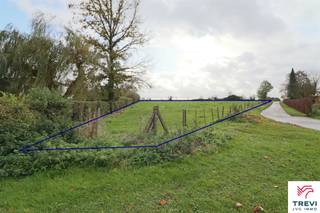 Grand et beau terrain à bâtir, de configuration plane, de +/- 59 ares sis en zone d'habitat à caractère rural. Façade de +/- 30 m (zone de recul à...