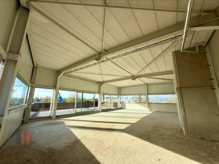 Nieuwbouw KMO-unit met <strong>showroom/magazijn en kantoor/conciërge woning</strong> van<strong> 399 m² </strong> in de Stadsbeemd te Halen.<br /><br />In de nieuwe en strategisch gelegen bedrijventerrein “STADSBEEMD”, vlakbij de bedrijvige Staatsbaan met een vlotte verbinding naar de E314 en het Klaverblad te Lummen, bieden wij deze hoogwaardige nieuwbouw KMO-unit aan. <br /><br />De unit bestaat uit een <strong>showroom/magazijn van 243 m²</strong> en een <strong>kantoorruimte/conciërge woning van 156 m² </strong>en is ideaal voor ondernemingen die zichtbaarheid, functionaliteit en bereikbaarheid willen combineren.<br /><br />De <strong>showroom/opslagruimte</strong> beschikt over een vrije hoogte van<strong> 3,5 m</strong> en is toegankelijk via een <strong>automatische sectionale poort </strong>(4,5 m H x 4 m B) en twee afzonderlijke toegangsdeuren. Dankzij de grote raampartijen geniet de ruimte van uitzonderlijk veel natuurlijke lichtinval en is het een sterke zichtlocatie. De unit is volledig geïsoleerd, afgewerkt met een polybetonvloer met een draagkracht van <strong>1 T/m². </strong>Onder de trap bevindt zich een technische ruimte.<br /><br />De <strong>kantoorruimte</strong> is zeer lichtrijk en kan zowel ingericht worden als kantoorruimte of als conciërgewoning met eigen terras. <br /><br />Verder beschikt de units over <strong>4 privatieve parkeerplaatsen met 1 laadpaal </strong>voor elektronische voortuigen<strong>.</strong> Ruime parkeer- en manoeuvreerruimte op de site. Voorziene oplevering: <strong>05/2026</strong>. <br /><br />Contacteer<strong> PANORAMA B2B</strong> voor bijkomende inlichtingen, plannen of een vrijblijvend plaatsbezoek op <strong>0474 17 17 15.</strong>