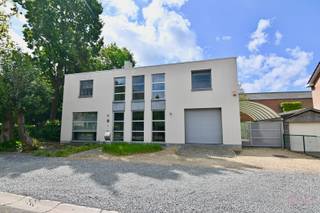 In een rustige doodlopende straat, op een uiterst centrale ligging nabij de N3 en N80 richting Tienen, Alken en omliggende gemeenten, bevindt zich deze uitzonderlijk knappe villawoning met een tijdloze architectuur en een hoogstaand afwerkingsniveau. Scholen, winkels, de Grote Markt, het LAGO-zwembad en tal van wandel- en fietsroutes bevinden zich op korte afstand, wat deze locatie niet alleen uiterst toegankelijk maar ook bijzonder kindvriendelijk maakt.<br /><br />Deze stijlvolle villa werd gebouwd in 1999/2000 volgens een vooruitstrevend architecturaal concept en werd doorheen de jaren met de grootste zorg onderhouden en verder gemoderniseerd naar hedendaagse normen. De combinatie van kwalitatieve materialen, royale volumes en overvloedige lichtinval zorgt voor een unieke woonbeleving waar comfort en elegantie perfect samenkomen.<br /><br />Via de ruime inkomhal met vestiaire en apart gastentoilet betreedt u een woning die meteen indruk maakt door haar openheid en licht. De inkomhal vormt het centrale hart van de woning en biedt bovendien ruimte voor een bureel of stijlvolle ontvangstruimte. De royale leefruimte met gezellige zithoek, eetkamer en leeshoek sluit naadloos aan op de open leefkeuken. Dankzij de vele grote raampartijen geniet elke ruimte van een prachtige connectie met de tuin en een overvloed aan natuurlijk licht. De volledig uitgeruste keuken beschikt over kwalitatieve toestellen van onder andere Electrolux (inductiekookplaat, microgolfoven, heteluchtoven), Miele (afwasmachine), AEG (koelkast) en NOVY (dampkap), afgewerkt met een elegant natuurstenen werkblad, dubbele spoelbak met afdruipzone en tal van praktische ingewerkte voorzieningen zoals diverse stopcontacten. Verder omvat het gelijkvloers een praktische wasplaats met toegang tot de tuin, veel maatwerkkasten en een ruime inpandige garage met zijdelingse ingang naar de carport.<br /><br />Op de verdieping creëert de mezzanine een prachtig ruimtelijk gevoel. Hier bevinden zich drie volwaardige slaapkamers, een aparte douchekamer, een afzonderlijk toilet én een luxueuze master suite met walk-in dressing en stijlvolle badkamer met ligbad.<br /><br />Ook de volledig ingerichte kelderverdieping biedt verrassend veel extra leefruimte en mogelijkheden. Hier vindt u onder andere een fitnessruimte, ontspanningsruimte, extra salon, technische ruimte, een kelderberging en een koude opslagruimte.<br /><br />Buiten geniet u van een volledig aangelegd en omheind perceel met een prachtig aangelegde, zuid geörienteerde tuin. Het ruime terras, de sfeervolle vijver, het tuinhuis en de verzorgde beplanting creëren een oase van rust en privacy. Extra troef is de bijkomende carport naast de woning.<br /><br />Bent u op zoek naar een instapklare villa met uitstraling, ruimte, luxe en een topligging? Aarzel dan niet en bel ons snel op 011 70 70 19 voor een afspraak.