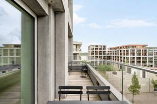 Cet appartement élégant est situé au quatrième étage de la tour résidentielle contemporaine « ZICHT », sur le site recherché du Nieuw Zuid. Grâce à sa situation autour de l’appartement, vous profitez d’un agréable espace extérieur et d’une abondante lumière naturelle.
Par le hall d’entrée, vous accédez à la lumineuse pièce de vie, dont le parquet en bois chaleureux crée immédiatement une atmosphère agréable et conviviale. La cuisine entièrement équipée, dotée de tous les appareils modernes, est attenante et intégrée à l’espace de vie.
L’appartement dispose également d’un débarras pratique avec raccordements pour lave-linge et sèche-linge, ainsi que de toilettes séparées pour les invités.
L’espace nuit comprend deux chambres spacieuses et deux salles de bains. La chambre principale dispose de placards intégrés et d’une confortable salle de bains privative. La deuxième chambre peut être aménagée de manière flexible en chambre, bureau ou chambre d’amis.
Les terrasses tout autour de l’appartement constituent un atout majeur. Elles offrent non seulement un espace extérieur supplémentaire, mais renforcent également la sensation d’espace et de luminosité dans tout l’appartement.
Il est possible d’acquérir deux emplacements de parking (45.000 euros par emplacement), ce qui rend l’ensemble particulièrement complet.