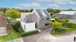 <strong>Unieke architectenwoning gelegen in rustige, groene omgeving in één van de mooiste wijken te Olmen, nabij Meerhout en Leopoldsburg. De villa biedt o.a. 4 à 6 ruime slaapkamers, 2 badkamers, een uiterst lichtrijke, open leefruimte en een diepe, organisch ingerichte natuurtuin (met zonneterrassen en infinity-zwembad). Het geheel ligt op een perceel van ca. 2.101m², uitzonderlijk gelegen nabij natuur (wandel- en fietsroutes) en achtergelegen agrarisch gebied. De abstracte woning ademt klasse, karakter, visie en rust. De woning en tuin zijn opgebouwd op verschillende niveaus, wat zorgt voor een speelse, open dynamiek. Pure materialen zoals zichtbeton, en hardhout staan centraal. De enorme raampartijen halen de natuurlijke omgeving naar binnen en zorgen voor een fascinerende beleving van licht en ruimte. De villa is bovendien uiterst energiezuinig (zonnepanelen, vloerverwarming, etc.). Nabij scholen, openbaar vervoer en natuurreservaten (Keiheuvel & Nationaal Park Bosland). <br /><br /></strong><em>Gelijkvloers verdiep - eerste niveau</em><br /><br />Via de inkomhal met vestiairegedeelte en gastentoilet heeft u toegang tot de afzonderlijke praktijkruimte, de technische ruimte en waskamer. Het praktijkgedeelte is voorzien van wachtruimte. De hal leidt verder tot het privé-gedeelte (woonkamer, keuken, etc.). De leefruimte is verdeeld in een zitgedeelte (linkerzijde) met zwevende houtkachel, het eetgedeelte met achterliggende bureauruimte (centraal) en de open leefkeuken (rechterzijde). Deze leefruimte geniet van veel natuurlijk daglicht door de riante raampartijen die uitgeven op de diepe natuurtuin met verhoogd infinity-zwembad en vijverpartij. De keuken - met aansluitend ontbijtgedeelte - op hoogte is uitgerust met alle nodige kwaliteitstoestellen: inductievuur, heteluchtoven, Quooker, vaatwas, etc. (AEG, Faber, e.a.).<br /><br />Via deze leefkeuken heeft u toegang tot de bijkeuken met extra gootsteen en inbouwkastruimte, alsook tot de zij-ingang (carport).<br /><br /><em>Bovenverdiep - tweede en derde niveau</em><br /><br />Op de bovenverdieping zijn er 3 ruime slaapkamers en een badkamer. De hoofdslaapkamer is voorzien van een eigen ensuite-badkamer (nog onafgewerkt) en een inloopdressing. Deze slaapkamer biedt een prachtig uitzicht op de tuin. De badkamer is voorzien van inloopdouche en toilet. De ingerichte zolderverdieping doet thans dienst als 4e slaapkamer maar kan perfect worden opgedeeld of worden gebruikt als multifunctionele ruimte (bv. hobbykamer).<br /><br /><em>Buiten- en tuingebeuren</em><br /><br />De woning biedt vooraan buitenparking op lavasteenkorrel. Parkeren kan zowel voor de woning als onder de carport in zichtbeton (met berging). Zowel in de voor- als achtertuin bevinden zich groenstructuren (hoge hagen, heesters en diverse typen grassen). De achtertuin is volledig aangelegd en ideeal georiënteerd op het oosten. De uitgestrektheid van deze tuin en de verschillende private terrassen zorgen ervoor dat u in verschillende tuindelen in alle sereniteit van zon of schaduw kan genieten. De natuurtuin is verder volledig omheind en organisch aangelegd. U vindt er naast verschillende heggen, bomen, heester en een aantal fruit- en notenbomen ook een infinity-zwembad (verwarmd én jetstream / tegenstroomsysteem). <br /><br /><span>Bijzonderheden</span>:<br /><span>- EPC van 93kWh/m²/jaar: energielabel A<br /></span>- Conforme elektrische keuring én asbestveilig<br />- Hoogwaardige inrichting en structuren/materialen: vijver, zwembad<br />- Bewoonbare oppervlakte van maar liefst 347<span>m² (excl. kelder)</span><span><br /></span>- CV op aardgas en vloerverwarming<br />- Zonnepanelen en batterijklaar<br />- Riant perceel op oosten: 2.101<span>m²</span><br />- Renovatiejaar 2020-2024<br /><br />Neem alvast een kijkje via de virtuele toer: https://tour.giraffe360.com/6e228dfe55ab4722a71b85186a3cb399/