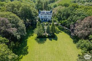 <p><span>Kasteel Ertbrand, u</span><span>niek kasteeldomein van ca. 5,7 ha in Kapellen</span></p><p><span> </span></p><p><span>Midden in een prachtig aangelegd parkdomein van ca. 57.000 m² ligt Kasteel Ertbrand. Het domein omvat het statige kasteel, een karaktervol voormalig koetshuis en een volwaardige tuinmanswoning.</span></p><p><span>Een eigendom van deze omvang en uitstraling is zeldzaam. Met zijn rijke geschiedenis, 3 royale residenties en uitgestrekte parkdomein vormt dit een unieke opportuniteit voor wie op zoek is naar een prestigieuze privéresidentie met tal van mogelijkheden.</span></p><p><span> </span></p><p><span>Het Domein</span></p><p><span> </span></p><p><span>Het prachtig aangelegde park vormt een oase van rust en privacy, met onder meer sierlijke vijvers, verzorgde hagen, volwassen groenstructuren en sfeervolle verzichten.</span></p><p><span>Hier geniet men van een uitzonderlijke woonomgeving waar natuur en exclusiviteit hand in hand gaan. </span></p><p><span>Een bijkomende meerwaarde is dat het kasteel, het koetshuis en de tuinmanswoning reeds zijn verkaveld in drie afzonderlijke percelen. Hierdoor biedt het eigendom niet alleen een unieke residentiële ervaring, maar ook interessante mogelijkheden naar de toekomst toe, waaronder een eventuele afzonderlijke verkoop van de verschillende residenties.</span></p><p><span> </span></p><p><span>Het Kasteel</span></p><p><span> </span></p><p><span>Het voormalige "Kasteel van Biart" werd na de Eerste Wereldoorlog afgebroken. Op deze historische locatie werd in 1920 het huidige Kasteel Ertbrand opgericht. De statige residentie beschikt over een bewoonbaar oppervlakte van circa 1.200 m² en straalt nog steeds de elegantie en grandeur uit van zijn bouwperiode.</span></p><p><span>Het kasteel omvat onder meer 10 slaapkamers en 4 badkamers, aangevuld met ruime leefvertrekken en ontvangstruimtes. De royale volumes, authentieke elementen en tijdloze uitstraling maken van het kasteel een uitzonderlijke woonervaring.</span></p><p><span>Naast zijn historische charme werd het kasteel doorheen de jaren zorgvuldig onderhouden. Zo werd het dak circa 10 jaar geleden vernieuwd, werden 20 zonnepanelen geplaatst en zorgen drie recente cv-ketels op aardgas voor een efficiënte en comfortabele verwarming.</span></p><p><span> </span></p><p><span>Het Koetshuis</span></p><p><span> </span></p><p><span>Naast het kasteel bevindt zich het voormalige koetshuis, met een bewoonbaar oppervlakte van circa 733 m². Dit gebouw werd in 2012 gerenoveerd en combineert vandaag karaktervolle elementen met hedendaags wooncomfort.</span></p><p><span>Het koetshuis omvat een ruime woning met 3 slaapkamers en 2 badkamers, aangevuld met een afzonderlijk appartement met 2 slaapkamers en 1 badkamer. Dankzij deze indeling biedt het talrijke mogelijkheden: van een gastenverblijf tot kangoeroewonen of een aparte woongelegenheid voor familieleden.</span></p><p><span>Als extra troef beschikt het koetshuis over een groot binnenzwembad, een sauna en meerdere garages.</span></p><p><span> </span></p><p><span>De Tuinmanswoning</span></p><p><span> </span></p><p><span>Het domein wordt vervolledigd door een charmante tuinmanswoning met een bewoonbaar oppervlak van circa 318 m². Deze volwaardige derde residentie beschikt over 3 slaapkamers en 2 badkamers en biedt eveneens diverse mogelijkheden binnen het geheel.</span></p><p><span> </span></p><p><span>Ligging</span></p><p><span> </span></p><p><span>Het domein is landelijk en in het groen gelegen, op een strategische locatie in Putte-Kapellen, nabij diverse voorzieningen en met een vlotte verbinding richting Brasschaat, Antwerpen en Nederland.</span></p><p><span> </span></p><p><span> </span></p><p><span>Contacteer ons voor meer informatie of om dit bijzondere domein persoonlijk te ontdekken.</span></p><p><span> </span></p>