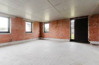 Deze casco woning biedt een uitzonderlijke kans om een unieke woonst volledig naar eigen smaak en wensen af te werken. De hoge plafonds en de grote verscheidenheid aan raampartijen zorgen voor een bijzonder open ruimtegevoel en een overvloed aan natuurlijke lichtinval. Het geheel is geen klassieke woning, maar een gedurfd architecturaal ontwerp met een uitgesproken karakter.<br /><br />Bij het betreden van de woning via de voordeur, gelegen uiterst links van het gebouw, komt u op de verdieping op straatniveau. Hier bevinden zich momenteel twee ruime slaapkamers, die eenvoudig kunnen worden opgesplitst tot vier slaapkamers, met vanuit de hal reeds de nodige deuropeningen. In elke kamer kan bovendien een kleine badkamer worden ingericht. In de hal is er mogelijkheid voor een afzonderlijk toilet en een lift. <br /><br />Daarnaast is er een bijzonder ruime multifunctionele ruimte aanwezig, die eveneens toegankelijk is via een afzonderlijke inkomdeur aan de rechterzijde van de woning. Deze ruimte is uitermate geschikt voor een vrij beroep of zelfstandige activiteit aan huis.<br /><br />Via de architecturale trap bereikt u de lager gelegen verdieping, waar zich het leefgedeelte bevindt. Hier vindt u een ruime en lichtrijke leefruimte met mogelijkheid voor een open keuken, aansluitende berging en eetplaats. Daarnaast is er nog een extra multifunctionele ruimte die kan worden ingericht als master bedroom met aansluitende badkamer en sauna, wellnessruimte, hobbykamer of bureau.<br /><br />Deze verdieping is eveneens rechtstreeks toegankelijk via een zijdelingse inkomdeur, wat een vlotte verbinding met de afzonderlijke garage mogelijk maakt. Aan deze inkom is mogelijkheid voor een vestiaire, een afzonderlijk toilet en een praktische wasruimte.<br /><br />De woning wordt casco aangeboden, waardoor zowel de indeling als de afwerking nog volledig vrij te bepalen zijn. Dit biedt een unieke opportuniteit om een woning te creëren die volledig aansluit bij uw eigen levensstijl.<br /><br />Voorstudie EPB resulteert in een E-peil van 20. <br /><br />Op de bovenste verdieping is een bijkomende wooneenheid voorzien, toegankelijk via een afzonderlijke inkom in het midden van de woning. Deze unit wordt eveneens casco aangeboden en kan afzonderlijk worden aangekocht, maar de aankoop van het geheel is uiteraard ook mogelijk.