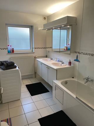 Ruim gelijkvloers appartement van 150 m² met terras en privéparking<br /><br />Dit ruime en comfortabele gelijkvloerse appartement van 150 m² maakt deel uit van een halfopen bebouwing en biedt alle comfort. Dankzij de praktische indeling en royale leefruimtes is het ideaal voor koppels, gezinnen, expats of zakenreizigers.<br /><br />Het appartement beschikt over een volledig uitgeruste keuken, een ruime leefruimte met zithoek, een inkomhal met nachthal, een apart toilet, twee grote slaapkamers en een badkamer.<br /><br />Buiten beschikt u over een ruim zuidgericht terras dat u volledig naar eigen smaak kunt inrichten. Bovendien beschikt het appartement over een privéparkeerplaats voor twee auto's.<br /><br />Dankzij de centrale ligging bevinden scholen, winkels en een bushalte zich op wandelafstand, waardoor u geniet van een uitstekende bereikbaarheid en alle dagelijkse voorzieningen binnen handbereik hebt.<br /><br />Het appartement behaalt een EPC-score C, wat wijst op een degelijke energieprestatie.<br /><br />Indeling:<br /><br />* Volledig uitgeruste keuken<br />* Ruime leefruimte<br />* Gezellige zithoek met televisie<br />* Inkomhal en nachthal<br />* Apart toilet<br />* 2 grote slaapkamers<br />* Badkamer<br />* Terras<br />* Privéparkeerplaats voor 2 auto's<br /><br />Gemeubelde verhuur is mogelijk.<br /><br />Een ideale woonst voor wie op zoek is naar ruimte, comfort en een praktische ligging in een aangename omgeving.<br />