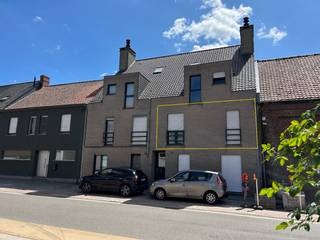 Centraal gelegen appartement op de 1e verdieping, met uitweg en garage achteraan in de Vlasstraat.<br /><br />Inkomhal, gastentoilet, badkamer, open keuken, leefruimte, berging en groot terras.<br />De twee slaapkamers zijn voorzien van rolluiken.<br />Het terras paalt aan de living en is bereikbaar via het schuifraam.<br />Er is een zonneluifel voorzien boven het schuifraam.<br /><br />Aluminium schrijnwerk en centrale verwarming op aardgas.<br /><br />Toegang tot het gebouw zowel van op de Rijksweg als vanuit de Vlasstraat.<br />De bijhorende garage heeft een kantelpoort en een achterdeur.<br /><br />Het appartement is momenteel verhuurd. Interessant voor zowel starters als voor investeerders.