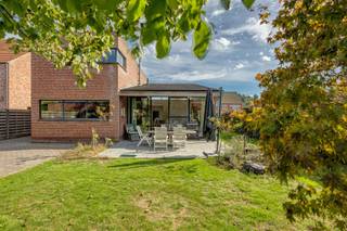 <p><strong>INDELING<br /></strong><span>Deze aangename woning combineert een praktische indeling met veel licht en ruimte. Dankzij de aanwezigheid van een slaapkamer en badkamer op het gelijkvloers is de woning bovendien geschikt voor wie comfortabel en toekomstgericht wil wonen.</span></p>
<p><span>Bij het binnenkomen wordt u verwelkomd in een </span><strong><span>lichtrijke leefruimte</span></strong><span>, uitgerust met mooie open haard, die mooi aansluit op de open keuken en zicht op de tuin. De keuken vormt het hart van de woning en biedt een fijne verbinding met de leefruimte. Aan de zij-ingang bevindt zich een </span><strong><span>praktische wasplaats</span></strong><span>, ideaal voor het dagelijkse gemak. De woning beschikt daarnaast over een <strong>praktische voorraadkelder</strong>.</span></p>
<p><span>Verder beschikt het gelijkvloers over een </span><strong><span>slaapkamer</span></strong><span>, een </span><strong><span>badkamer met zowel douche als bad</span></strong><span>, een aparte </span><strong><span>bureauruimte</span></strong><span> en een praktische </span><strong><span>hobbyhoek</span></strong><span>. </span></p>
<p><span>Op de eerste verdieping bevinden zich nog </span><strong><span>twee slaapkamers</span></strong><span> en een tweede badkamer met douche.</span></p>
<p><span>Ook buiten heeft deze woning heel wat te bieden. De </span><strong><span>mooie, noordwest georiënteerde tuin</span></strong><span> vormt een aangename plek om te genieten van de buitenlucht. Rechts op het perceel bevindt zich bovendien een </span><strong><span>aparte garage met werkplaats van 52m²</span></strong><span>, handig voor het stallen van een wagen, fietsen of extra bergruimte. Voorraan zijn er ruime parkeerplaatsen.<br /></span></p>
<p><strong><span>Een veelzijdige woning met een aangename tuin, drie slaapkamers en heel wat praktische troeven – zeker een bezoek waard!<br /><br />BIJZONDERHEDEN<br /></span></strong>Op het vlak van comfort is de woning uitgerust met verwarming op aardgas, vloerverwarming op het gelijkvloers en radiatoren op de verdieping. De leefruimte werd recent voorzien van airconditioning, terwijl een ventilatiesysteem zorgt voor een aangenaam binnenklimaat.<strong><span><br /><br />POSITIEVE ASPECTEN<br /></span></strong>Mooi perceel<br />Gunstige woonligging<br />Veel natuurlijke lichtinval<br />Hedendaags comfort<br />Goed onderhouden woning<br />Ruime garage</p>