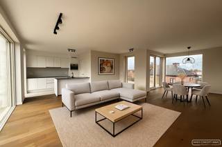 <h3>Indeling van het penthouse</h3>

<p>Dit stijlvolle nieuwbouwappartement biedt een <strong>lichtrijke leefruimte</strong> met directe toegang tot zowel het <strong>voor- als achterterras</strong>. Het achterterras is uitgerust met een zonneluifel en <strong>kijkt uit op het parkje</strong> achter het gebouw, wat zorgt voor een aangenaam en rustig uitzicht. De <strong>open keuken</strong> met eiland is volledig ingericht met moderne toestellen en sluit naadloos aan op de leefruimte. Verder is er een <strong>praktische wasplaats/berging</strong> en zijn er twee volwaardige slaapkamers aanwezig. De <strong>badkamer</strong> is uitgerust met een <strong>inloopdouche en een dubbel lavabomeubel</strong>, en er is een <strong>apart gastentoilet</strong> voorzien. Ondergronds beschikt het appartement over een <strong>autostaanplaats met een afgesloten berging</strong>. Dankzij de <strong>vloerverwarming</strong> en <strong>warmtepomp</strong> is het appartement bovendien bijzonder energiezuinig. Met een bewoonbare oppervlakte van 105 m² en 37 m² terrassen geniet je hier van een ruime woonbeleving. Het appartement werd <strong>volledig geschilderd en voorzien van lichtarmaturen</strong>, waardoor het instapklaar is.</p>

<h4>Praktisch</h4>

<ul>
	<li>Huurprijs: € 900 + € 50 autostaanplaats + € 50 syndic</li>
	<li>Onmiddellijk beschikbaar </li>
</ul>

<h4>Interesse? Vraag een bezoek aan</h4>
Vraag een bezoek aan via sarah@maesconceptimmo.be.