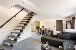 Geen zin in jaren verbouwen, torenhoge energiefacturen of een woning die technisch alweer achterhaald is? Dan hebben we goed nieuws. Deze kwaliteitsvol gerenoveerde woning van maar liefst 175 m² combineert verrassend veel ruimte met hedendaags comfort, slimme technologie én bijzonder energiezuinig wonen.<br /><br />Binnenkomen doe je via de inkomhal, waarna de woning zich meteen van haar beste kant laat zien. De royale open leefruimte biedt plaats aan een gezellige zithoek, ruime eetplaats én een aparte speelhoek of bureau. Ideaal voor wie graag ruim woont, regelmatig thuiswerkt of gewoon houdt van dat tikkeltje extra bewegingsvrijheid.<br /><br />Ook de keuken mag gezien worden. Mooi afgewerkt, voorzien van kwalitatieve materialen alsook alle mogelijke toestellen en helemaal klaar voor gezellige etentjes, snelle ontbijtjes of avonden met vrienden.<br /><br />En dan zijn er de technieken: 2 warmtepompen, maar liefst 16 zonnepanelen en vloerverwarming op het gelijkvloers houden het wooncomfort hoog en het energieverbruik onder controle. Op warme zomerdagen zorgen de airco's op het gelijkvloers én in de slaapkamers voor verkoeling, terwijl ze ook kunnen bijverwarmen wanneer gewenst.<br /><br />Nog slimmer? De woning beschikt over een uitgebreid domoticasysteem waarmee je onder andere verlichting, temperatuur en verschillende technieken eenvoudig via je smartphone bedient. Thuiskomen was nog nooit zo comfortabel.<br /><br />Op de eerste verdieping bevinden zich twee bijzonder ruime slaapkamers van elk circa 20 m². Daarnaast is er nog een extra kamer die vandaag dienst kan doen als stockage, maar evengoed kan worden ingericht als dressing of bureau.<br /><br />De ruime badkamer is uitgerust met een inloopdouche en dubbele wastafel. Daarnaast is er een afzonderlijk toilet. De inpandige garage wordt momenteel gebruikt als berging, terwijl je voor de woning over een eigen parkeerplaats beschikt.<br /><br />Ook buiten werd gekozen voor gemak. De onderhoudsvriendelijke buitenruimte met kunstgras laat je vooral genieten in plaats van werken. De achtergevel kan bovendien nog volledig naar eigen smaak worden afgewerkt, ideaal voor wie toch graag zijn eigen stempel op de woning drukt.<br /><br />Beperkt KI van 359 EURO, EPC 36 kWh – A label, 175 m² woonruimte, slimme domotica, warmtepompen, vloerverwarming, airco's én 16 zonnepanelen: hier koop je niet alleen een gerenoveerde woning, maar vooral het wooncomfort van morgen.<br /><br />Klaar om zelf te ontdekken hoe slim en comfortabel wonen kan zijn? Contacteer Vastima en plan vandaag nog jouw bezoek.