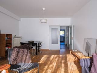 <strong>Een stijlvol éénslaapkamer-appartement in de Sportstraat, met een warm mid-century karakter en hedendaags wooncomfort.</strong><br /><br />Het appartement (<strong>BVO 102 m²</strong>) op de <strong>gelijkvloerse verdieping</strong> geniet van een open stadsbeleving dankzij het brede zicht op twee samenlopende woonstraten. Dit zorgt voor een aangename, warme lichtinval, de hele dag door.<br /><br />De residentie zelf, een <strong>kleinschalig en goed onderhouden gebouw met tien units</strong>, ademt het rustige, residentiële karakter van de Sportstraat.<br /><br />Binnen verbindt de <strong>centrale inkomhal</strong> met zithoek en vestiaire alle ruimtes van de woning. Aan de straatzijde ligt de <strong>leefruimte met eetplaats</strong>, waar het materiaalgebruik, de natuursteen en het originele schouwelement met strakke lijnen zorgen voor <strong>een tijdloze ‘60s-uitstraling</strong>.<br /> <br />De <strong>keuken</strong>, met <strong>wasplaats</strong>, ligt aan de achterzijde en biedt via een groot raam toegang tot de <strong>buitenruimte</strong> en de omgeving.<br /><br />De <strong>slaapkamer</strong> is zeer ruim en voorzien van <strong>grote raampartijen</strong>. De <strong>rustige oriëntatie</strong> maakt dit tot een aangename, stille plek.<br /><br />De <strong>badkamer</strong> is compact maar functioneel, uitgerust met <strong>douchebad</strong>, <strong>wastafel</strong> en geïntegreerde <strong>opbergruimte</strong>.<br /><br />De vernieuwde inkomhal, <strong>kelderbergingen</strong>, <strong>garageboxen (€ 40.000)</strong> en een gedeelde <strong>fietsenstalling</strong> creëren een praktische en aangename woonomgeving.<br /> <br />Het appartement, <strong>gelegen nabij Gent-Sint-Pietersstation en het stadscentrum</strong>, combineert hedendaags comfort met de authentieke charme van de jaren ’60: <strong>een evenwicht tussen vintage karakter en vernieuwde technieken, tussen eenvoud en warmte.</strong><br />