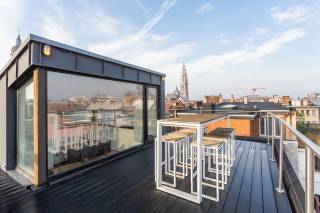 Midden in het historische hart van Antwerpen, aan de Keizerstraat, bevindt zich dit stijlvolle penthouse op een absolute toplocatie. U woont hier letterlijk op wandelafstand van de Grote Markt, de Meir, de Groenplaats en het bruisende stadsleven met zijn talrijke restaurants, gezellige cafés en winkels. Een unieke combinatie van centraal wonen en thuiskomen in alle rust, met als absolute troef een ruim dakterras met prachtige zichten over de stad.<br /><br />Bij het betreden van het appartement wordt u onmiddellijk verrast door de ruime en bijzonder lichtrijke leefruimte. De grote raampartijen zorgen voor een overvloed aan natuurlijk licht en creëren een aangenaam gevoel van ruimte. De mooie parketvloer, gecombineerd met de sfeervolle haard, geeft het geheel een warme en karaktervolle uitstraling. De open keuken sluit perfect aan bij de leefruimte en is uitgerust met de nodige inbouwtoestellen.Vanuit de keuken is er bovendien toegang tot een praktische berging. Het appartement is daarnaast voorzien van airconditioning, wat zorgt voor extra comfort.<br /><br />Het slaapgedeelte bevindt zich achteraan en is bereikbaar via de nachthal, die voorzien is van een volledige wand met ingemaakte kasten. De master bedroom beschikt over een ensuite badkamer met dubbele wastafel, ruime inloopdouche en toilet. Daarnaast bevindt zich een tweede volwaardige slaapkamer, eveneens voorzien van ingemaakte kasten. De tweede badkamer beschikt over een wastafel en ligbad. Een afzonderlijk gastentoilet vervolledigt het appartement.<br /><br />De bovenverdieping is momenteel ingericht als bureau en biedt, afhankelijk van uw wensen, de mogelijkheid om een derde slaapkamer te creëren. Vanuit deze ruimte heeft u rechtstreeks toegang tot het ruime dakterras, dé troef van deze penthouse, waar u geniet van unieke zichten over de Antwerpse binnenstad.<br /><br />Tot slot is er een parking bij aan te kopen aan 45.000 EUR. <br /><br />Interesse in deze unieke woonst?<br />Contacteer LISTED voor een bezoek: +32 283 51 51.