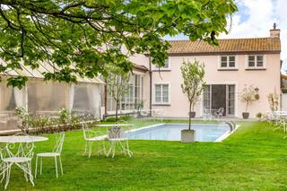 In de villa vormen licht, ruimte en comfort de rode draad. De riante leefruimte vloeit dankzij de kamerhoge raampartijen naadloos over in het terras en de tuin met zicht op het zwembad. Met vier ruime slaapkamers biedt de woning de nodige flexibiliteit voor een ruime gezinswoning. De drie badkamers sluiten hier perfect op aan. Het handelsgedeelte huisvest een volledig uitgebouwde horecazaak die direct operationeel is. De sfeervolle restaurantzaal met elegante rondboogramen en glazen deuren straalt klasse uit. De professionele keuken is uitgerust met alle nodige faciliteiten, waaronder een koelcel. Als kers op de taart is er het riante, overdekte terras: de ideale plek om gasten te ontvangen in een rustgevende, groene setting.Ben je op zoek naar de ultieme combinatie van wonen en werken? Contacteer ons dan op het nummer 011 30 50 54 of mail naar ines.bollen@dewaele.com.