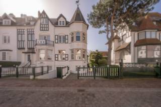 In één van de mooiste lanen van Duinbergen, op wandelafstand van de mini-golf en de zee, bevindt zich deze statige en karaktervolle villa. Gelegen in een pittoreske buurt met een uitgesproken standing, ademt deze eigendom pure klasse en een permanent vakantiegevoel aan zee.<br /><br />Deze exclusieve villa werd ontworpen door architect Jozef Viérin en is een prachtig voorbeeld van de eclectische stijl. Het silhouet wordt gekenmerkt door charmante puntgevels en speelse in- en uitspringende gevelvlakken, gevormd door erkers en loggia’s, wat zorgt voor een unieke en tijdloze uitstraling.<br /><br />Binnenin wordt U verwelkomd in een woning met hoge plafonds, authentieke elementen en een smaakvolle inrichting die perfect aansluit bij het karakter en de allure van het pand. De aparte ingangen maken deze woning bijzonder geschikt voor een gezin met au-pair.<br /><br />De buitenruimte bestaat uit een aangenaam zonneterras en een gezellig tuintje, ideaal om in alle rust te genieten van het buitenleven. Een absolute troef van deze eigendom is de aanwezigheid van een garage én twee staanplaatsen, wat in deze gegeerde buurt een zeldzaamheid is.<br />Kortom, een uitzonderlijke villa met een authentiek karakter, op een topligging in Duinbergen — perfect als vaste woonst of exclusief vakantieverblijf aan zee.<br /><br />Bent u op zoek naar een unieke eigendom met charme, standing en een topligging aan zee? Neem vandaag nog contact op voor een bezoek ter plaatse en laat U betoveren door deze bijzondere villa.