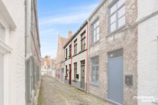 Een eigen stukje Brugge, naar jouw smaak te vormen.<br /><br />In het hart van de historische binnenstad, in een rustige eenrichtingsstraat nabij de idyllische Langerei, wacht deze karaktervolle stadswoning op een nieuwe eigenaar met een visie. Hier koop je geen kant-en-klaar verhaal, maar een te renoveren woning met mogelijkheden.<br /><br />Gelijkvloers<br />Je stapt binnen in een gezellige leefruimte die alle kanten op kan: ontvangen, ontspannen of werken, dat bepaal je zelf. Onder de trap bevindt zich een berging. De compacte open keuken sluit naadloos aan op de leefruimte. Via de keuken stap je naar de knusse stadskoer. De badkamer is voorzien van een douche, lavabo, toilet, een elektrische boiler en een aansluiting voor de wasmachine. <br /><br />Verdieping<br />Op de eerste verdieping vind je twee slaapkamers. Vanuit één ervan geeft een uitschuifbare trap toegang tot de zolder die extra opbergruimte biedt. <br /><br />Waarom dit pand?<br />• Unieke locatie: centrum Brugge, op wandelafstand van markten, terrasjes, winkels en openbaar vervoer<br />• Rustig gelegen in een eenrichtingsstraat, weinig verkeer en veel sfeer<br />• Nabij de Langerei, een van de mooiste en meest geliefde buurten van de stad<br />• Asbestvrij, dus een zorgeloze start voor je renovatie<br />• Renovatieproject met alle vrijheid om het pand volledig naar eigen smaak en budget af te werken<br />• Perfect als starterswoning of investering<br /><br />Voor wie?<br />Of je nu op zoek bent naar een eerste eigen stek, een investeringspand voor verhuur, of een tweede verblijf in de Brugse binnenstad: dit huis biedt de ideale basis. Met wat creativiteit en een goed renovatieplan maak je er een pareltje van, in een stad waar vastgoed zijn waarde behoudt.<br />Bij interesse, contacteer snel ons kantoor.