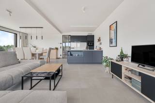 Dit kwalitatief appartement (met lift) werd opgetrokken in 2022 met veel aandacht voor energie, licht, ruimtegevoel en gebruik van hoogwaardige materialen. De indeling is als volgt: inkomhal, gastentoilet, aangename leefruimte waar de grote raampartijen een enorm wow gevoel geven, aangenaam zonneterras van ca 9m2 waar het heerlijk vertroeven is, open keuken voorzien van alle toestellen en voldoende opbergkasten. De nachthal geeft toegang tot de twee ruime slaapkamers, volledig betegelde badkamer met inloopdouche, dubbele lavabo+meubel. Het appartement beschikt eveneens over een handige berging/wasplaats. extra's: zonnescreens aanwezig, overal vloerverwarming met warmtepomp, verluchtingssysteem D, privatieve zonnepanelen, nog vrijstelling op kadastraal inkomen. Inclusief kelderberging. Aankoop van een ondergrondse autostaanplaats (25 000 euro). IDEAAL VOOR WIE RUSTIG WIL WONEN MAAR TOCH DIRECT IN EN UIT HET CENTRUM EN IN DE NABIJHEID VAN ALLE INVALSWEGEN!