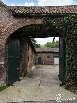 Droom je van een landelijke woonplek met geschiedenis, karakter en ruimte om je eigen plannen vorm te geven? Aan de Cabergstraat 2 in Mopertingen, Bilzen-Hoeselt, ontdek je deze hoeve uit 1891. Met een karakteristieke boogpoort, een sfeervolle binnenkoer en een perceel van 9961m² vormt dit een bijzonder vertrekpunt voor een prachtig renovatieproject.<br /><br />De hoeve beschikt momenteel over 264 m² bewoonbare oppervlakte. De historische uitstraling maakt dit een plek voor wie authentieke elementen waardeert en ze wil combineren met hedendaags wooncomfort.
<h1><strong><span>Indeling en buitenruimte</span></strong></h1>
Via de boogpoort bereik je de binnenkoer, het centrale hart van de hoeve geheel in landelijke uitstraling. De bestaande woonvertrekken en bijgebouwen bieden mogelijkheden om een indeling uit te werken die aansluit bij jouw woonwensen, rekening houdend met de bouwkundige toestand en de geldende voorschriften. Tijdens een bezoek ontdek je hoe de verschillende ruimtes zich tot elkaar verhouden.<br /><br />Ook buiten geniet je van een uitzonderlijk gevoel van ruimte en rust. Het uitgestrekte perceel van circa 9961m² biedt een prachtige groene omgeving met tal van mogelijkheden om volop van het buitenleven te genieten. De combinatie van ruimte, privacy en het landelijke karakter maakt deze eigendom tot een bijzondere plek met heel wat potentieel.
<h1><strong><span>Troeven</span></strong></h1>
<ul>
<li>Authentieke gesloten hoeve uit 1891.</li>
<li>Karakteristieke boogpoort en centrale binnenkoer.</li>
<li>264 m² bewoonbare oppervlakte.</li>
<li>Ruim perceel van 99a61</li>
<li>Landelijke ligging in Mopertingen (Bilzen-Hoeselt).</li>
<li>Mogelijkheden voor een renovatieproject.</li>
</ul>
<br />Deze hoeve te koop in Mopertingen ligt aan de rand van de dorpskern. De achterliggende velden en weilanden versterken het landelijke Haspengouwse karakter. Tegelijk geniet je van verbindingen naar Bilzen en Maastricht: een aangename combinatie voor wie groen wil wonen en de omliggende steden vlot wil bereiken.<br /><br />Zie jij jouw toekomst in deze karaktervolle hoeve? We nemen je graag mee voor een rondleiding en bekijken samen de mogelijkheden.<br />Contacteer Optie M via info@optie-m.be of 011 23 11 01.<br /><br />Wil je weten wat jouw woning waard is? Contacteer ons gerust via bovenstaande gegevens.<br /><br />GVG - WGLK + LWAG - GMO - GVV