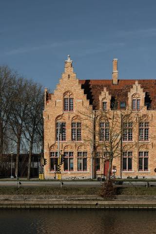 Na jaren van leegstand kreeg het hoekgebouw langs de Sint-Pieterskaai intussen een nieuw leven. Wat ooit het vertrouwde politiecommissariaat was, werd intussen omgevormd tot een uniek woonproject dat geschiedenis en modern wooncomfort op harmonieuze wijze samenbrengt. In dit karaktervolle pand worden 6 stijlvolle appartementen en 3 aantrekkelijke handelsruimtes gerealiseerd, elk met een eigen indeling en uitstraling. De appartementen zijn ontworpen met respect voor het verleden en worden afgewerkt met hoogwaardige materialen die de authentieke sfeer van het gebouw versterken. De appartementen beschikken over een ruim privaat terras met diverse zichten en oriëntaties.<br /><br />Appartement A6 wordt als volgt ingedeeld: ruime inkomhal met apart gastentoilet, ruime open keuken volledig voorzien van maatwerk, lichtrijke leefruimte met directe toegang tot het terras en prachtig zicht. Het appartement beschikt over 3 volwaardige slaapkamers en een ruime badkamer met inloopdouche, dubbele wastafel en extra toilet. Er is tevens een ruime technische bergruimte en een bijkomende zolderruimte die eveneens als berging kan dienen. <br />In de ondergrondse parkeergarage, te bereiken met autolift, bevinden zich parkeerplaatsen en kelderbergingen.<br /><br /><strong>Enkele troeven van dit appartement:</strong>
<ul>
<li>Uniek appartement op een boogscheut van centrum Brugge;</li>
<li>Energiezuinig met 50% korting gedurende 5 jaar op de onroerende voorheffing; </li>
<li>Prachtige raampartij met een lengte maar liefst 8m;</li>
<li>3 ruime slaapkamers;</li>
<li>Ruim terras van 19,58 m² met prachtig zicht;</li>
<li>Volledig afgewerkt, geschilderd en voorzien van verlichting. </li>
</ul>
<br />Op zoek naar een woonst met ziel dat zowel historiek als toekomst ademt?<br />Dan nodigen we u van harte uit om de mogelijkheden te ontdekken en een afspraak in te plannen.<br />