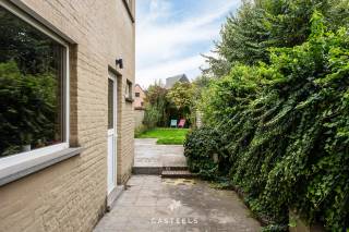 Deze rijwoning in de Loofblommestraat combineert een praktische indeling met een fijne buitenruimte. Met twee ruime slaapkamers, een zolder met mezzanine en een tuin met terras is ze geschikt voor wie comfortabel wil wonen, dicht bij alle voorzieningen.<br /><br />Leefruimte<br />De living is het hart van de woning. De parketvloer geeft de ruimte een warme uitstraling. De houtkachel zorgt in de koudere maanden voor gezelligheid en extra comfort.<br />Vanuit de leefruimte bereikt u het terras en de tuin. Zo loopt binnen en buiten vlot in elkaar over.<br /><br />Slaapkamers en zolder<br />Op de 1ste verdieping bevinden zich twee ruime slaapkamers.<br />Daarboven ligt nog een zolder met mezzanine en lavabo. Deze ruimte biedt mogelijkheden: een bureau om thuis te werken, een hobbyruimte of een extra plek voor logees. U kiest zelf wat het best bij uw manier van wonen past.<br /><br />Badkamer en wasruimte<br />De badkamer is voorzien van zowel een bad als een inloopdouche. Daarnaast is er een aparte wasruimte. Wasmachine en droogkast staan zo uit het zicht en de badkamer blijft een rustige ruimte.<br /><br />Tuin, terras en zij-ingang<br />Het terras en de tuin zijn een fijne plek om buiten te zitten of te ontspannen.<br />Een praktische troef is het poortje aan de zijkant van de woning. Fietsen en vuilnisbakken brengt u zo rechtstreeks naar achteren, zonder door de woning te moeten. Voor een rijwoning is dat een comfort dat u dagelijks merkt.<br /><br />Ligging<br />De woning ligt centraal, met de dagelijkse voorzieningen op korte afstand. Bakker, slager en frituur bereikt u te voet. Ook de Carrefour Hypermarkt ligt op wandelafstand.<br /><br />Voor gezinnen is de nabijheid van basisschool Westerhem, om de hoek, een duidelijk pluspunt.<br /><br />Ook de bereikbaarheid zit goed:<br />De bushalte Loofblommestraat ligt op minder dan 100 meter.<br />Een Blue-bike-station vindt u in het dorpscentrum.<br />Met de wagen zit u snel op de E40.<br />Het centrum van Gent is vlot bereikbaar.