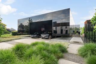 Deze uitzonderlijke nieuwbouwwoning, ontworpen door Binst Architects, is veel meer dan een woning, het is een krachtig architecturaal statement. Een strak paviljoenconcept vertaalt zich in een stijlvolle “black box” die zich bewust afzet tegen de omgeving en tegelijk volledig opgaat in het achterliggende landschap.<br /><br />De woning wordt gekenmerkt door een spel van contrasten: gesloten en open, licht en donker, privacy en transparantie. Zwartgelakt glas en gefumeerde beglazing zorgen voor een unieke, tijdloze uitstraling, terwijl grote glaspartijen overvloedig daglicht binnenbrengen en het zicht op de tuin en het zwembad maximaliseren.<br /><br />De leefruimte bevindt zich op de bovenverdieping en zweeft als het ware boven het terrein, met een panoramisch uitzicht op het omliggende groen. De slaapkamers zijn discreet geïntegreerd in een half ondergrondse verdieping, wat zorgt voor rust, privacy en een aangenaam binnenklimaat.<br /><br />Buiten wordt het architecturale verhaal doorgetrokken met een subliem afgewerkt overloopzwembad (infinity pool) dat visueel één wordt met het landschap, aangevuld met een stijlvol poolhouse. Hier ervaart u elke dag het gevoel van een exclusief privéresort.<br /><br />Troeven:<br />- Uniek ontwerp door Binst Architects<br />- Iconisch “black box” concept in zwartgelakt glas<br />- Infinity pool en luxueus poolhouse<br />- Maximale lichtinval en panoramisch uitzicht<br />- Doordachte indeling met gescheiden woon- en slaapniveau<br />- Absolute privacy en rust<br /><br />Deze woning laat zich niet vatten in woorden alleen: dit is een beleving.<br /><br />Bel ons voor meer informatie of een discreet bezoek.