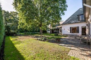 Op een uitstekende locatie te Berlaar bevindt zich deze ruime gezinswoning met vijf slaapkamers, zwembad en handelsruimte, gelegen op een mooi perceel van maar liefst 33a 83ca. Dankzij de gunstige ligging bevinden winkels, scholen, horeca en het openbaar vervoer zich op wandelafstand, terwijl u thuis geniet van rust en ruimte.<br /><br />We betreden de woning via de inkomhal, voorzien van een vestiaire en gastentoilet. De lichtrijke leefruimte wordt gekenmerkt door de vele raampartijen en biedt alle ruimte voor een gezellige zithoek en aparte eetplaats. De keuken sluit mooi aan op de leefruimte en is uitgerust met de voornaamste toestellen. Naast de keuken bevindt zich nog een ruimte die kan ingericht worden als bureau/zithoek/eetplaats. Via deze extra leefruimte komen we terecht bij het overdekt terras, met zicht op de tuin. Ook buiten heeft deze woning heel wat te bieden. De volledig aangelegde tuin met zwembad vormt een heerlijke, groene oase waar u in alle rust en privacy kunt genieten van het buitenleven en mooie zomerdagen. Aan parkeergelegenheid is er evenmin een gebrek. De woning beschikt over een ruime oprit en een inpandige garage met aanpalende bergruimte. En hier stopt het nog niet, want het gelijkvloers heeft nog enkele verrassingen. Er is een aparte ingang aanwezig die toegang geeft tot een handelsruimte, op de eerste verdieping, van maar liefst 83m². Deze ruimte zou ingericht kunnen worden als studio. Ook vooraan de woning is er een extra kamer voorzien die kan ingericht worden als handelsruimte of als gelijkvloerse slaapkamer met berging, douchekamer en apart toilet. Via de prachtige trappenhal komen we in de nachthal van de eerste verdieping terecht. Deze geeft ons toegang tot 4 ruime slaapkamers, aparte toiletruimte en de badkamer, voorzien van dubbele lavabo en ligbad. De woning beschikt tevens over een kelder- en zolderruimte.<br /><br />Dit is een uitstekende opportuniteit als u op zoek bent naar een ruime villa met vijf slaapkamers en eventuele handelsruimte op een groen perceel te Berlaar. Contacteer ons voor meer informatie op 0472 82 80 66 of neem een kijkje op www.boonstravastgoed.be. <br /><br />Bijzonderheden: <br />- 5 slaapkamers<br />- Bewoonbaar oppervlakte 617 m²<br />- Ruim perceel 3383m² met zwembad