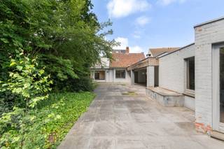 <p>Bent u op zoek naar een woning waar <span>wonen en werken</span> perfect gecombineerd kunnen worden? Of droomt u van een <span>kangoeroewoning</span> of een <span>ruime gezinswoning met tal van mogelijkheden</span>? Dan is deze uitzonderlijk ruime woning (438 m²) in het centrum van Maldegem precies wat u zoekt.</p>
<p>De woning geniet van een centrale ligging met alle voorzieningen op wandelafstand: winkels, scholen en openbaar vervoer bevinden zich in de onmiddellijke omgeving. Bovendien is er een vlotte verbinding naar zowel de kust als het binnenland.</p>
<p>Bij het betreden van het pand vallen meteen de twee afzonderlijke ingangen op: één naar de voormalige tandartsenpraktijk en één naar de privéwoning, met onderlinge doorgang tussen beide units.</p>
<p><strong>Via de eerste ingang</strong> bereikt u de praktijkruimte, bestaande uit een inkomhal met gastentoilet, een aparte berging, wachtruimte, bureauruimte en twee voormalige kabinetten. Deze ruimtes zijn uitgerust met airconditioning en lenen zich perfect voor een vrij beroep of kunnen ingericht worden als een volwaardige tweede woonunit.</p>
<p><strong>De tweede ingang</strong> leidt naar de ruime privéwoning. U komt binnen in een royale inkomhal met ingemaakte vestiairekasten en gastentoilet. De lichtrijke leefruimte omvat een gezellige eetplaats en woonkamer met open haard. Aansluitend bevindt zich de open keuken met extra eetruimte. Deze hoogwaardige Siematic-keuken is uitgerust met een natuurstenen werkblad, Amerikaanse koelkast met vriezer, gas- en inductiekookzones, Venduro dampkap, Miele inbouwfriteuse, extra brede oven, combi-oven en dubbele spoelbak. Verder is er een unieke inloopkoelcel voorzien in de hal, evenals een praktische wasplaats met ingemaakte kasten en extra bergruimte.</p>
<p>Op de <span>eerste verdieping</span> bevinden zich vijf volwaardige slaapkamers en twee badkamers, elk uitgerust met lavabo en douche. De <span>tweede verdieping</span> herbergt een prachtige master bedroom met ensuite badkamer voorzien van lavabo, bubbelbad, douche en toilet. Ook hier is airconditioning aanwezig voor optimaal comfort.</p>
<p>Daarnaast beschikt de woning over een praktische <span>kelder</span>.</p>
<p>Buiten geniet u van een gezellig, <span>ingesloten terras</span> dat rechtstreeks toegankelijk is vanuit de keuken. Achteraan bevindt zich een <span>ruime tuin met een groot aangelegd terras</span>, deels overdekt en voorzien van een open haard – ideaal om het hele jaar door te genieten. Verder zijn er meerdere tuinbergingen met extra zolderruimte en vaste trap.</p>
<p>Vooraan is er een <span>oprit</span> met plaats voor twee wagens. Bovendien bestaat de mogelijkheid om naast de woning een garage te huren met ruimte voor drie wagens.</p>
<p>Kortom: <span><strong>een veelzijdige eigendom met tal van mogelijkheden op een toplocatie in Maldegem.</strong></span><br /><br />Benieuwd naar de mogelijkheden? <br /><span>Contacteer Bonne Vastgoed 7 op 7 via 050/73.73.73 of info@bonnevastgoed.be</span></p>
