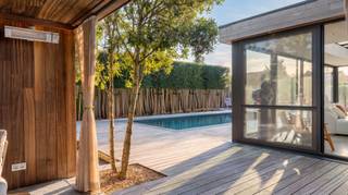 Sur un magnifique terrain de 815 m² dans un quartier résidentiel à Knokke-Heist, se trouve cette spacieuse villa avec piscine, poolhouse et plusieurs places de parking. La propriété bénéficie d'un emplacement particulièrement central, à proximité du centre de Knokke et du village de Westkapelle, avec un accès facile à toutes les principales routes d'entrée.<br /><br />La villa a été construite en 1990 et offre aujourd'hui une superficie habitable de 307 m². Elle a été entièrement rénovée esthétiquement au fil des ans, conférant aux espaces intérieurs et extérieurs de cette propriété une apparence contemporaine, chaleureuse et soignée.<br /><br />L'allée avec carport offre un stationnement pour plusieurs véhicules. Le vaste hall d'entrée donne accès à un toilette pour invités avec toilettes japonaises. Au rez-de-chaussée, vous trouverez également le garage et une pièce polyvalente pouvant servir de chambre, bureau ou cabinet.<br /><br />Le salon spacieux avec cheminée s'ouvre sur la cuisine ouverte, entièrement équipée avec coin repas et un four AGA au caractère unique. Adjacente à la cuisine se trouve une buanderie avec rangement et accès direct à la terrasse.<br /><br />La véranda avec de grandes fenêtres laisse entrer beaucoup de lumière naturelle et renforce la sensation d'intérieur-extérieur qui est perceptible dans toute la villa.<br /><br />Les stores équipant la véranda font partie d'un choix réfléchi à travers toute la maison : toutes les fenêtres et ouvertures peuvent être fermées, garantissant confort en toute saison. La véranda constitue ainsi la transition naturelle vers le jardin.<br /><br />Le jardin paysager offre intimité et tranquillité, avec une piscine chauffée, une douche extérieure, un espace lounge et un poolhouse avec toilettes séparées.<br /><br />La suite parentale dispose d'un dressing avec sauna intégré et d'une salle de bains attenante avec double lavabo, douche à l’italienne, baignoire et dressing. En outre, il y a deux chambres spacieuses avec une salle de bains partagée. Dans le couloir de nuit, il y a un toilette pour invités séparé.<br /><br />À l'étage se trouve une grande chambre avec placards intégrés et l'ancienne atelier de bijoutier. Cet espace est idéal pour un logement invités, une salle de loisirs ou d'autres usages.<br /><br />La maison est équipée d'une technologie résidentielle avancée, notamment des installations électriques gérées par la domotique, des panneaux solaires, la climatisation, une pompe à chaleur, le chauffage et l'éclairage pilotables à distance, l'arrosage automatique et un réseau de caméras étendu.<br /><br />Vous êtes intéressé ? Contactez l'agence immobilière NANO au 050 60 60 78 ou à info@immonano.be.