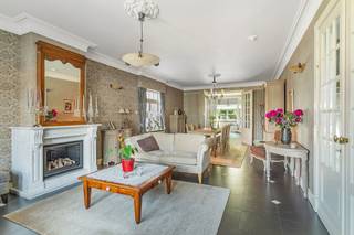 <p>Dit stijlvolle herenhuis in Dessel is gelegen op een perceel van 875 m² en heeft een bewoonbare oppervlakte van ca. 302 m².</p>
<p><strong>Gelijkvloers</strong></p>
<p>Bij het betreden van de inkomhal wordt meteen duidelijk dat dit een huis met karakter is. Rechts bevindt zich een eerste slaapkamer met badkamer, voorzien van een douche, lavabo en toilet – ideaal als luxueuze gastenruimte.</p>
<p>Verder leidt de inkomhal naar de ruime, gezellige leefruimte. Dankzij de sfeervolle gashaard kunt u in de zithoek tijdens kille winteravonden in alle comfort genieten. Verder bestaat de leefruimte nog uit een eetkamer en een open bureaugedeelte.</p>
<p>De keuken sluit mooi aan op de leefruimte en biedt niet alleen een praktische indeling, maar ook een prachtig uitzicht op de aangelegde tuin. Dankzij de grote ramen geniet u hier van overvloedig daglicht en een aangename openheid.</p>
<p>Op het gelijkvloers bevindt zich tevens een apart gastentoilet.</p>
<p><strong>Eerste verdieping</strong></p>
<p>De elegante trap brengt u naar de eerste verdieping, waar u maar liefst 4 slaapkamers aantreft. De master bedroom beschikt over een eigen inloopkast en badkamer, uitgerust met douche, lavabo en toilet. Daarnaast beschikt de eerste verdieping over een extra badkamer uitgerust met een bad en een dubbele lavabo. Hiernaast bevindt zich een apart toilet.</p>
<p><strong>Zolder</strong></p>
<p>De vaste trap leidt verder naar de grote zolderverdieping. Deze riante ruimte biedt talloze mogelijkheden en kan volledig naar wens worden ingericht – bijvoorbeeld als extra slaapkamers, hobbyruimte of atelier.</p>
<p><strong>Tuin en garage</strong></p>
<p>De prachtig aangelegde en uitstekend onderhouden tuin vormt een oase van rust, waar u volop kan genieten van de buitenlucht.</p>
<p>Links van de woning bevindt zich de ruime garage.</p>
<p><strong>Kelder</strong></p>
<p>Er is een droge kelder onder de helft van de woning en de andere helft is een vlot toegankelijke kruipruimte.</p>
<p><strong>Extra’s</strong></p>
<p>Dit herenhuis combineert zijn statige uitstraling met moderne voorzieningen. Zo is de woning uitgerust met zonnepanelen, airco en thuisbatterij en geniet u van een gunstig energielabel.</p>
<p><strong>Troeven</strong></p>
<ul>
<li>Bewoonbare oppervlakte: ca. 302 m²</li>
<li>5 slaapkamers</li>
<li>Vaste trap naar de grote zolder</li>
<li>Ruime, aangelegde tuin</li>
<li>Gunstig energielabel (164 kWh / (m² jaar))</li>
<li>Zonnepanelen, thuisbatterij, airco</li>
</ul>