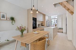 Instapklare en recent gerenoveerde woning met hoogwaardige afwerking, gelegen in de Arsenaalstraat 70 te Gentbrugge. Deze stijlvolle woning combineert een moderne uitstraling met praktisch wooncomfort en een doordachte indeling.Op het gelijkvloers geniet u van een open en lichtrijke leefruimte met een prachtige maatwerkkeuken, eetplaats en gezellige living. Dankzij de grote raampartijen en lichtinval voelt het geheel bijzonder ruim aan. Aansluitend bevindt zich een aangename zuidwestgerichte koer waar u volop van de middag- en avondzon geniet. Aan de inkomhal is er een apart gastentoilet voorzien. Tal van ingemaakte kasten zorgen overal in de woning voor extra bergruimte en een strak geheel.De eerste verdieping omvat een ruime master bedroom met ingemaakte kasten en een stijlvolle badkamer uitgerust met ligbad, dubbele lavabo, inloopdouche en toilet. Ook hier werd maximaal ingezet op een verfijnde afwerking.Op de tweede verdieping bevinden zich nog twee slaapkamers, waarvan één bijzonder ruime kamer die tal van mogelijkheden biedt als slaapkamer, bureau of hobbyruimte.Verder beschikt deze woning over een gunstig EPC-label B, conforme elektriciteit en een asbestveilig attest. Met een bruto bewoonbare oppervlakte van ca. 120 m² is dit de ideale woning voor wie op zoek is naar comfort, kwaliteit en een instapklaar geheel op een vlotte ligging nabij Gent centrum, winkels en openbaar vervoer.Bestuursmaatregelen in het maatregelenregister: nee
