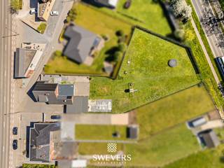 Voor meer info en foto’s, surf naar www.swevers.be – Tongersesteenweg 98 in Tongeren-Borgloon is een instapklare woning met veel ruimte, een praktische indeling en interessante mogelijkheden voor de toekomst. De woning werd gebouwd in 1958 en biedt een ruime bewoonbare oppervlakte van 265 m² op een perceel van 18a 65ca. Op het gelijkvloers vind je een aangename leefruimte met woonkamer van 34,11 m², aansluitend op de eetkamer en de keuken van 17,80 m². De indeling zorgt voor een vlotte verbinding tussen wonen, koken en eten. Daarnaast zijn er een berging en wasruimte aanwezig. Een grote troef is de slaapkamer van 17,36 m² op het gelijkvloers. Hierdoor is de woning geschikt voor wie gelijkvloers wil slapen of werken, maar ook voor wie denkt aan kangoeroewonen of een zorggerichte woonoplossing. Op de eerste verdieping bevinden zich nog drie slaapkamers van 17,21 m², 12,50 m² en 12,10 m², samen met de badkamer. De zolder en kelder van 30,11 m² zorgen voor bijkomende opslagruimte of mogelijke extra invulling. Buiten geniet je van een ruim perceel met plaats om te ontspannen, te tuinieren of kinderen te laten spelen. De 35 zonnepanelen vormen een extra pluspunt voor wie energiezuinig wil wonen. Ook de ligging is praktisch: winkels, scholen, bushalte en ontspanning bevinden zich vlakbij, met vlotte verbindingen naar station en snelweg. Deze woning combineert vier slaapkamers, veel bergruimte, een groot perceel en toekomstpotentieel op een bereikbare locatie. Voor meer informatie, bel 012 699 900. Bron bewoonbare oppervlakte: EPC – verslag.