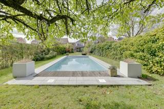 <p><span>Ontdek deze verzorgde halfopen gezinswoning in het gegeerde Aartselaar, rustig gelegen tussen het dorpshart en de A12. Een woning waar bereikbaarheid en wonen in alle rust elkaar versterken, en waar de indeling vanzelfsprekend aanvoelt in het ritme van elk gezin.</span></p><p><span> </span></p><p><span>Binnen ontvouwt zich een doordachte leefstructuur die ruimte geeft én verbindt. De eetkamer vormt de centrale schakel tussen keuken en woonkamer en wordt subtiel verbonden met de inkomhal. Ingemaakte kasten en een geïntegreerde bureau zijn hier naadloos ingewerkt in het geheel, functioneel zonder de rust van de ruimte te verstoren.</span></p><p><span> </span></p><p><span>De keuken, vernieuwd in 2014, sluit rechtstreeks aan op de tuin en laat binnen- en buitenleven in elkaar overvloeien. Grote raampartijen brengen het groen naar binnen, terwijl de tuin zich als vanzelf uitstrekt tot een extra leefruimte in de warmere maanden. Het geheel wordt omkaderd door een diepe tuin die privacy en ademruimte biedt.</span></p><p><span> </span></p><p><span>De woonruimte kan bovendien worden afgesloten, waardoor de woning zich moeiteloos aanpast aan het moment: open en verbonden wanneer gewenst, rustig en afzonderlijk wanneer nodig. De gashaard voegt daar een warme, ingetogen sfeer aan toe.</span></p><p><span> </span></p><p><span>Op de eerste verdieping bevinden zich drie volwaardige slaapkamers met aangename lichtinval. De badkamer sluit hier eigentijds op aan en biedt het nodige comfort voor het dagelijks gebruik. De ingerichte zolderverdieping werd voorzien een ruime vierde kamer, flexibel inzetbaar naar ieders wensen, en biedt daarnaast nog mogelijkheden voor een wasplaats of het creëren van een tweede badkamer.</span></p><p><span> </span></p><p><span>Buiten wordt het wonen verdergezet in een diepe, groene tuin waar het zwembad een natuurlijke blikvanger vormt. Een plek die zomers vertraagt en het buitenleven vanzelfsprekend maakt. De oprit voor twee wagens vervolledigt het praktische comfort van deze woning.</span></p><p><span> </span></p><p><span>Bijzonderheden</span></p><ul><li><span>Halfopen bebouwing</span></li><li><span>4 slaapkamers</span></li><li><span>Elektriciteit conform AREI</span></li><li><span>Zonnepanelen aanwezig</span></li><li><span>Ingemaakte kasten</span></li><li><span>Oprit voor twee wagens</span></li><li><span>Strategische ligging tussen dorpskern en A12</span></li></ul><p><span> </span></p><p><span>Op zoek naar een instapklare gezinswoning met ruimte, licht en een uitstekende ligging in Aartselaar? Contacteer ons via <span>thomas.onzia@urbainvastgoed.be</span></span><span> of bel 0478/22.78.63 voor meer informatie of een bezoek.</span></p><p><span> </span></p>