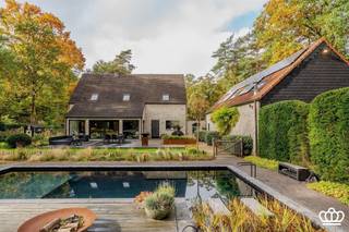 <p><span>Centraal gelegen, instapklare villa met magazijn en o.a. ruime leefruimte, ingerichte keuken, bureelruimte, kelder, 6 slaapkamers, 3 badkamers en zwemvijver op een oost georiënteerd perceel van 4.500 m².</span></p><p><span> </span></p><p><span>INDELING</span></p><p><span> </span></p><p><span>Gelijkvloers</span></p><p><span>Inkomhal op tegelparket, vestiaireruimte, gastentoilet met handenwasser, aparte bureelruimte met ingemaakte kasten en zijdeur naar buiten.  Vanuit de inkomhal toegang tot de zeer ruime leefruimte onderverdeeld in zit- en eetgedeelte.  Deze ruimte geniet veel lichtinval door de grote raampartijen die uitgeven op de tuin.  Aansluitend ingerichte keuken voorzien van koelkast met vriesvak, Miele combi-oven-micro, aparte Miele microgolfoven, vaatwasser, inductievuur, dampkap en dubbele porseleinen wasbak.</span></p><p><span> </span></p><p><span>Eerste</span><span> </span><span>verdieping</span></p><p><span>Op de eerste verdieping is een ruime nachthal die uitgeeft op 2 slaapkamers met ingemaakte kasten die met elkaar verbonden zijn door een douchekamer.  Verder zijn er nog 2 slaapkamers waarvan 1 met ingemaakte kasten en een eigen douchekamer voorzien van douche en wastafel.  De gehele verdieping, uitgezonderd de badkamers zijn op parket.</span></p><p><span> </span></p><p><span>Tweede verdieping</span></p><p><span>D.m.v. vaste trap toegang tot de tweede verdieping.  Hier bevinden zich nog 2 slaapkamers en een zolderruimte.  De tweede verdieping is op laminaatvloer.  </span></p><p><span> </span></p><p><span>Kelder</span></p><p><span>Kelder met voorziening wasmachine en droogkast.  Hier bevinden zich tevens de technische installaties.</span></p><p><span> </span></p><p><span>Tuin</span></p><p><span>Automatische toegangspoort met vooraan veel parkeergelegenheid.  Apart bijgebouw (garage) met automatische poort, dit pand met zolderruimte biedt meerdere mogelijkheden.  Achteraan prachtig aangelegde tuin, volledig omheind die veel privacy geniet met hybride zwemvijver.</span></p><p><span> </span></p><p><span>Bijgebouw</span></p><p><span>Ruim bijgebouw/magazijn met voorziening water en elektriciteit waar zich ook de omvormer van de zonnepanelen bevindt.</span></p><p><span>Deze ruimte is voorzien van vaste trap met volwaardige zolder.</span></p><p><span> </span></p><p><span>Bijzonderheden</span></p><p><span>-Centraal gelegen nabij uitvalswegen naar Antwerpen en Nederland</span></p><p><span>-Ruim bijgebouw (garage) met diverse mogelijkheden</span></p><p><span>-Zonnepanelen </span></p><p><span>-Prachtig aangelegde tuin met hybride zwemvijver</span></p><p><span> </span></p>