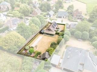 Op een prachtig perceel van maar liefst 1.101 m² bevindt zich deze charmante villa, idyllisch gelegen in de gegeerde Leiestreek. Een unieke woonomgeving waar rust, natuur en bereikbaarheid perfect samenkomen.<br /><br />De woning ligt op wandel- en fietsafstand van het Ooidonk Kasteel en het schitterende omliggende natuurgebied, met de schilderachtige Oude Leie-arm als absolute troef. Hier geniet u van eindeloze wandelingen, fietstochten en pure rust, terwijl u toch een uiterst strategische ligging behoudt.<br /><br />De villa beschikt op het gelijkvloers over een ruime inkomhal, een praktische berging, apart toilet, bureel, een kamer, badkamer, keuken en garage. Op de verdieping zorgt een gezellige overloop voor extra polyvalente ruimte, ideaal als thuisbureau, leeshoek of speelruimte. Deze geeft toegang tot twee ruime slaapkamers en een badkamertje met toilet en lavabo. <br /><br />Maar het is vooral de prachtig aangelegde en verzorgde tuin die deze woning bijzonder maakt. Het royale perceel biedt volop privacy en ruimte om te genieten van het buitenleven, met onder meer een tuinberging, petanquebaan en vijver. Dankzij de zonnige ligging vormt de tuin een heerlijke plek om tot rust te komen of gezellig samen te genieten.<br /><br />Een uitzonderlijke combinatie van ruimte, natuur en rust op een toplocatie in de Leiestreek. Een woning met karakter, gelegen op een perceel waar het elke dag genieten is.