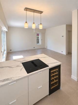 <p><span>Volledig gerenoveerd 1-slaapkamerappartement met ca. 40 m² buitenruimte in Schoten</span></p><p><span>Op een </span><span>uiterst rustige locatie in Schoten</span><span>, op wandelafstand van het kanaal, bevindt zich dit </span><span>volledig gerenoveerde gelijkvloerse appartement</span><span> met één slaapkamer en maar liefst </span><span>ca. 40 m² private buitenruimte</span><span>.</span></p><p><span>Het appartement werd grondig en kwalitatief gerenoveerd. </span><span>Alle leidingen en technieken werden vernieuwd</span><span>, het appartement werd geïsoleerd en voorzien van </span><span>vloerverwarming</span><span>. Ook de ramen werden volledig vernieuwd en zijn uitgerust met </span><span>elektrische rolluiken</span><span>.</span></p><p><span>Via de inkomhal betreed je het appartement. Hier bevindt zich een praktische ingebouwde kast met ruimte en aansluitingen voor </span><span>wasmachine en droogkast</span><span>, waardoor deze netjes uit het zicht kunnen worden geplaatst.</span></p><p><span>De lichtrijke leefruimte sluit naadloos aan op de </span><span>volledig uitgeruste open keuken</span><span>. Deze beschikt over een koelkast, diepvries en een </span><span>Bosch oven en microgolfoven</span><span>. Het ruime kookeiland is voorzien van een kookplaat met </span><span>geïntegreerde dampafzuiging</span><span> en een </span><span>ingebouwde wijnkast</span><span>. De stijlvolle verlichting boven het eiland zorgt voor extra sfeer. Dankzij de oversteek van het werkblad is er bovendien voldoende plaats om enkele barkrukken te plaatsen.</span></p><p><span>Het appartement beschikt over </span><span>één slaapkamer</span><span>, bereikbaar via een mooi geïntegreerde schuifdeur. Ook de badkamer is voorzien van een ingebouwde schuifdeur en werd met veel aandacht voor detail afgewerkt. Ze beschikt over een toilet, een stijlvol badkamermeubel met </span><span>natuurstenen waskom</span><span>, een </span><span>verlichte en verwarmde spiegel</span><span> en een </span><span>zeer ruime inloopdouche</span><span>.</span></p><p><span>Ook aan buitenruimte is er geen gebrek. Aan de achterzijde bevindt zich een </span><span>volledig omheind terras van ca. 25 m² met westoriëntatie</span><span>, ideaal om te genieten van de namiddag- en avondzon. Via een afsluitbaar poortje is het appartement bovendien rechtstreeks langs het terras toegankelijk.</span></p><p><span>Daarnaast beschikt het appartement over het </span><span>private gebruik van ca. 15 m² tuin aan de voorzijde van het appartementsgebouw</span><span>. Samen biedt dit appartement dus maar liefst </span><span>ca. 40 m² private buitenruimte</span><span>, verdeeld over de voor- en achterzijde.</span></p><p><span>Een </span><span>volledig instapklaar appartement</span><span> met een hoogwaardige afwerking, hedendaags wooncomfort en een bijzonder rustige ligging op wandelafstand van het kanaal.</span></p><p><span>Garagebox verplicht bij aan te kopen aan 25.000 €.</span></p><p><span>Troeven:</span><span> </span></p><p><span>- volledig gerenoveerd </span></p><p><span>- vloerverwarming vernieuwde leidingen en technieken</span></p><p><span>- geïsoleerd </span></p><p><span>- lage EPC</span></p><p><span>- asbestvrij</span></p><p><span>- nieuwe ramen met elektrische rolluiken </span></p><p><span>- uiterst rustige ligging nabij het kanaal </span></p><p><span> </span></p><p><span>Lage gemeenschappelijke kosten want geen lift aanwezig!</span></p>
