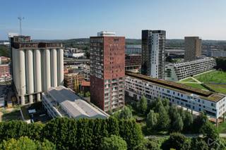 <p>In de iconische residentie “<strong>Twist</strong>” aan het Stapelhuisplein vind je dit prachtige appartement op de eerste verdieping. Het gebouw ligt aan de <strong>bruisende Vaartkom</strong>, een van de meest begeerde wijken van Leuven, waar wonen, werken en ontspannen naadloos samenkomen. Met de <strong>haven vlak voor de deur</strong> en een waaier aan trendy restaurants, gezellige bars en culturele hotspots op wandelafstand, geniet je hier dagelijks van de unieke sfeer van dit heroplevende stadsdeel.<br /><br />Het appartement zelf werd ontworpen met oog voor <strong>licht en ruimte</strong>. De grote leefruimte vloeit natuurlijk over in de open keuken en het zuidgerichte terras, dat de hele dag zon en warmte biedt. Hier kan je in alle rust genieten van een koffiemoment, terwijl je uitkijkt op de skyline van Leuven én het groene park achter het gebouw. Het grote schuifraam in de leefkamer is voorzien van <strong>screens</strong>, ideaal voor een gunstig binnenklimaat. De keuken is uitgerust met een hoogwaardige <strong>Bulthaup-installatie</strong> en alle moderne voorzieningen, waardoor koken en leven samen een beleving worden.<br /><br />Naast stijlvol is dit appartement ook duurzaam: met een <strong>EPC-label A</strong> ben je verzekerd van een energiezuinige woning die klaar is voor de toekomst. Het combineert de voordelen van hedendaags comfort met de charme van een toplocatie. Je woont in een <strong>bruisende buurt</strong> vol dynamiek en tegelijkertijd met een groene oase binnen handbereik, een zeldzame troef in de stad.<br /><br />Dit appartement is dan ook de perfecte keuze voor wie houdt van <strong>modern en comfortabel wonen</strong>, in het hart van Leuven, met alles binnen handbereik en toch omringd door rust en natuur. Plan vandaag nog je bezoek en laat je overtuigen door de unieke charme van dit uitzonderlijke aanbod.</p>