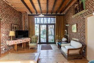 Deze uitzonderlijk ruime woning in het centrum van Haaltert biedt enorm veel plaats en tal van mogelijkheden. Dankzij de verschillende leefruimtes is de eigendom perfect geschikt voor een groot gezin, een kangoeroewoning of een combinatie van wonen en werken. Op het gelijkvloers vind je meerdere gezellige leefruimtes, twee slaapkamers en een functionele keuken met gasfornuis. Aansluitend is er een praktische berging met een authentieke houtoven. Een van de slaapkamers beneden beschikt over een vaste trap naar de ingerichte zolder, die voorzien is van een eigen douche en toilet. Op de verdieping bevindt zich een bijzonder ruime leefruimte, een extra living, een badkamer met ligbad en een grote zolderkamer die ideaal kan dienen als bijkomende slaapkamer, hobbyruimte of atelier. Ook buiten heeft deze eigendom heel wat te bieden. Je ontspant op het overdekte terras of het tweede terras, met daartussen een mooie vijver die zorgt voor een rustige sfeer. Vooraan ligt een ruime binnenkoer, terwijl je achteraan beschikt over een grote, groene tuin met verschillende fruitbomen en heel wat privacy.