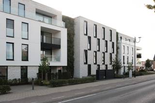 <p>Lichtrijk gelijkvloers appartement met 3 slaapkamers en ruim terras in centrum Oud-Turnhout</p><p>Dit ruime (137 m2) gelijkvloerse BEN 20 appartement ligt in het recente nieuwbouwproject Ter Dijke (bouwjaar 2022) vlakbij het centrum van Oud-Turnhout, met winkels, scholen en openbaar vervoer op wandelafstand.</p><p>De leefruimte, eetruimte en keuken (55 m2) vormen samen één brede, lichtrijke ruimte die uitkijkt op het groene terras. De keuken heeft kwalitatieve inbouwtoestellen zoals inductie kookplaat, oven, microgolfoven, afwasmachine en inbouwkoelkast van Siemens, een keukeneiland met opbergschuiven en ingemaakte kasten. Een ruime berging van 7,5 m2 aansluitend bij de keuken zorgt voor extra opbergruimte. Hier vind je ook het mechanische ventilatiesysteem, type D.</p><p>Er zijn twee ruime slaapkamers, waarvan één met ingemaakte kast, en een kleinere derde slaapkamer die ook geschikt is als bureau of logeerkamer. De hoofdslaapkamer heeft aansluitend een eigen badkamer met naast douche, wastafel en toilet ook een ingemaakte kastenwand.<br />De tweede badkamer heeft een douche, wastafel met vier schuiven en een ingemaakte kast..<br />Daarnaast ligt een extra berging met aansluiting voor wasmachine en droogkast.</p><p>Bij het appartement horen twee parkeerplaatsen met een breedte van 3,5 m (achter elkaar) in de ondergrondse parking en een ruime berging van 7,2 m2.</p><p>In de ondergrondse parking is er een gemeenschappelijke fietsenberging met fietsenlift en een ruimte voor de vuilniscontainers.</p>