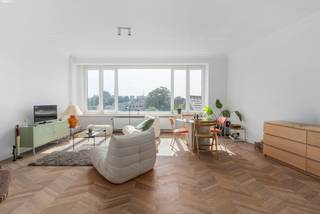 <p><strong>Recent gerenoveerd appartement met drie slaapkamers en een klein terras, op de grens van de Markgravewijk en de Harmoniewijk. Het hele appartement ademt een luxe look-and-feel uit met onder andere warme parketvloeren, moderne tegelvloeren, prachtige zichten en hoge plafonds.</strong></p>
<p><strong>Indeling:</strong><br />Via de inkomhal met apart toilet betreedt men de grote, <b>zeer lichte</b> leefruimte dankzij de brede raampartijen. Centraal bevindt zich de keuken die toegang verleent tot het <b>oostgerichte</b> terras. De uitgestrekte keuken is voorzien van een vaatwasser, ijskast, diepvriezer, <b>elektrische</b> kookplaat, oven, een ruime spoelbak en voldoende opbergruimte. Vanuit de nachthal bereikt men de badkamer met inloopdouche (voorzien van grote wandtegels) en een wastafel.</p>
<p>Achteraan het appartement bevinden zich de drie ruime slaapkamers, tevens voorzien van <b>hoogwaardig</b> parket.<br /><br /><strong>Bijzonderheden:</strong><br />Privatieve kelderberging;<br />Maandelijkse kosten: ca. €225 per maand (inclusief beheer, blokpolis, verbruik/onderhoud van de algemene delen inclusief lift + <span>provisie voor water en verwarming</span>);<br /><br /><strong>Ligging:<br /></strong>Centraal gelegen met een ideale verbinding naar de invalswegen rond <b>de stad</b>, met vlakbij het Domein Hertoghe, de Wezenberg, het Harmoniepark en de Singel. In de straat zelf bevinden zich bovendien tal van winkels, restaurants en supermarkten. Openbaar vervoer en vélostations bevinden zich op minder dan 100 meter wandelafstand!</p>
