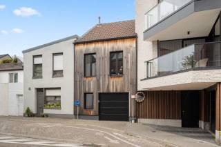 In het centrum van Tienen op 300 m van het station en 200 m van het mooie en groene stadspark ligt deze mooie rijwoning waarvan de achtergevel werd bekleed met hout. Op het gelijkvloers is er een gang met ruime vestiaire en wc. Tevens is er een bureel of slaapkamer, een berging / wasplaats en een grote garage die uitgeeft in de straat achteraan, zijnde de Raemaeckersvest. <br />Bij open poort beschik je zo eigenlijk over een leuk terrasje. Op de eerste verdieping is de ruime leefruimte met open nieuwe geïnstalleerde keuken met kookeiland en vaste eettafel . Op dezelfde verdieping is er een nieuwe badkamer met inloopdouche, lavabo en toilet, alsook een tweede grote slaapkamer. Op de tweede verdieping is er een derde zeer grote slaapkamer van ruim 30 m². Er is een nieuwe hoog rendementsketel op aardgas met nieuwe radiatoren. De elektriciteit is conform. Er is ook een kelder maar geen tuin (200 m van stadspark). Het EPC zit in de B -klasse, dus voor lange tijd gerust! Voor deze woning is zeer snel zijn de ultieme boodschap!<br /> <br />