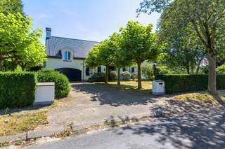 Deze villa geniet van een uitstekende ligging in een doodlopende straat, midden in een groene villawijk van ’s-Gravenwezel. Het dorpscentrum met winkels, horeca, scholen en dagelijkse voorzieningen bevindt zich op korte afstand, terwijl ook Schilde en de omliggende gemeenten vlot bereikbaar zijn. Een aantrekkelijke woonomgeving waar het groene karakter en een uitstekende bereikbaarheid mooi samenkomen.<br /><br /><strong>Indeling</strong><br />Via de oprijlaan met voldoende parkeergelegenheid bereikt u de villa, die toegankelijk is via zowel de centrale inkomhal als de dubbele inpandige garage.<br />De inkomhal met vestiaire en gastentoilet leidt naar de gezellige zithoek met houthaard en aansluitende eetkamer. Daarnaast bevindt zich een polyvalente ruimte, momenteel ingericht als tweede zithoek, maar eveneens geschikt als bureau, lees- of hobbyruimte.<br />De grote raampartijen zorgen voor een overvloed aan natuurlijk licht en bieden vanuit de leefruimtes een prachtig zicht op het terras, de vijver en de fraai aangelegde tuin.<br />Aansluitend aan de eetkamer bevindt zich de uitgeruste keuken met veranda. Dankzij het panoramische zicht over de tuin vormt deze een aangename extra leefruimte. Vanuit de keuken bereikt u tevens de dubbele garage, voorzien van extra bergruimte en aansluitingen voor wasmachine en droogkast.<br /><br /><strong>Verdieping</strong><br />Op de eerste verdieping bevinden zich drie volwaardige slaapkamers, waarvan twee zeer ruim en voorzien van ingemaakte kasten. De master bedroom beschikt over een badkamer (recent gerenoveerd) ensuite met ligbad, douche, lavabo en toilet, evenals een riant privéterras.<br />Daarnaast is er op deze verdieping een afzonderlijk toilet aanwezig.<br />Tot slot beschikt de woning over een praktische opbergzolder, wijnkelder en kruipruimte.<br /><br /><strong>Tuin</strong><br />De fraai aangelegde tuin geniet van een uitstekende zuidoriëntatie en vormt een mooie aanvulling op de leefruimtes. Het terras met vijver creëert een sfeervolle plek om van de tuin te genieten, terwijl achteraan het perceel nog een praktisch tuinhuis aanwezig is.<br /><br /><strong>Bijzonderheden</strong><br />+ Deze architecturale werd in 1976 gebouwd door architect Laporta<br />+ Conforme elektrische installatie<br />+ Gegeerde residentiële ligging<br />+ Zuidgeoriënteerde tuin<br />+ 3 volwaardige slaapkamers<br />+ Dubbele inpandige garage<br />+ Dak recent vernieuwd en geïsoleerd<br />+ Wijnkelder en praktische opbergzolder<br /> 