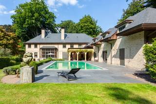 Deze riante villa heeft een zee van ruimte en een prachtig aangelegde parktuin met buiten zwembad en tennis, een echte familie-villa, een thuis! De villa heeft een uiterst gezellige leefkeuken met met prachtige open-haard. De keuken is zeer stijlvol en straalt vanwege de mooie duurzame materialen en luxe toestellen een zeer rustgevende sfeer uit. Via de schuifraam toegang naar het overdekte terras waar het zalig vertoeven is. Ook toegang naar de de riante tuin met uiterst veel privacy! Er is een zeer ruime living met grote open-haard, hier is er een grote raampartij waardoor binnen en buiten één geheel vormen. Er is een speels tv-kamer met open-haard en aanpalend een bureau ( dat afgesloten kan worden) met stijlvolle ingemaakte bibliotheek. Er is een grote eetkamer met authentieke stoof. De ruime gang breng ons naar de cosy bar. Ideale plek om vrienden te ontvangen. Er is ook een nog een afzonderlijke bureau-ruimte. De perfecte plek voor de kids om hun huiswerk te maken, vlakbij de keuken. De zij-inkom brengt ons naar de mudroom en de wellness ruimte met sauna, douche, kleedkamers, fitness. Hier directe toegang naar het zwembad en de tuin. De tuin met tennis is adembenemend en nodigt uit voor een wandelingetje. Op de verdieping zijn er 2 mooie slaapkamers met communicerende badkamer. De master bedroom met grote badkamer met ligbad, inloopdouche, toilet, pissin en dubbele lavabo. Er is een 4de en 5de grote slaapkamer. Een mooie badkamer met douche , ligbad en dubbele lavabo+toilet. Eer ruime wasplaats met extra spoelbak. Op de 2de verdieping is er een grote polyvalente ruimte die voor meerdere doeleinden kan dienen. Lift tot de 2 de verdieping. Er is een droge , functionele kelder + wijnkelder. Alarm, domotica, volledig omheind, automatische poort, bijhuis. Tennis met gravel. Buitenverlichting, beregeningsinstallatie, deze villa is voorzien van alle luxe. Parkeerplaats voor 6 wagens. Mogelijkheid tot carport. Kortom, deze villa is een riante villa met één sfeer, een thuis voor wie wil wonen in alle luxe en een oase van groen, een aanrader!!! Privacy alom! Epc B LABEL, AREI CONFORM, GEEN ASBEST.Voor meer info: www.domus-immobilien.be of bel Irene 0475/653581. Het is absoluut de moeite een bezoek ter plaatse te brengen!